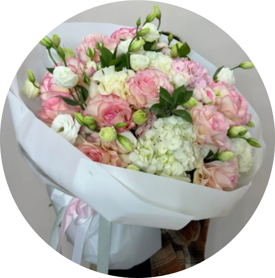 PALOMA - Soft pink and white roses gathered around a generous white hydrangea create a lush, rounded bouquet that reads as quietly romantic - perfect as an anniversary bouquet, wedding gift, or a thoughtful Mother's Day surprise. The hand-tied design presents a full, abundant silhouette that will make the person you're thinking of feel truly celebrated and seen.  This arrangement combines closely packed rose heads, a prominent hydrangea cluster, and airy lisianthus buds in a pastel palette of pink, white, and soft green. Wrapped in crisp white paper and finished with a pale pink ribbon, the bouquet arrives polished and gift-ready with a refined, feminine look that photographs beautifully and commands attention in any room.  Send this bouquet to mark birthdays, engagements, or sentimental moments when you want to convey tenderness and admiration. Designed to be enjoyed right away, keep blooms in fresh water, recut stems at an angle, and refresh vase water regularly to extend their life.
