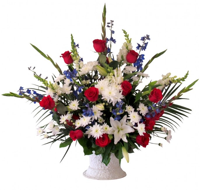 Red roses and white lilies in a white vase with blue and white flowers
