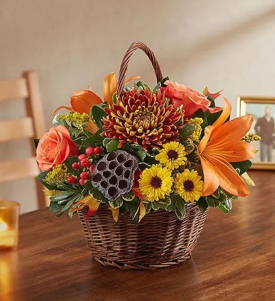 Peace, Prayers and Blessings for Fall - We find comfort in caring words and kind gestures during times of loss. Offer your own thoughtful expression with our lovely basket arrangement in warm autumn colors. Designed by expert local florists, this touching tribute will help convey all the love in your heart.  All-around basket arrangement with orange roses and Asiatic lilies, red hypericum, bronze football mums and yellow Viking poms; accented with solidago, assorted greenery, dried oak leaves and lotus pods Artistically designed in a handled willow basket; measures 8"H Appropriate for sending to the homes of family members or friends Large arrangement measures approximately 13"H x 13"W Medium arrangement measures approximately 12"H x 12"W Small arrangement measures approximately 11"H x 11"W Our florists hand-design each arrangement, so colors, varieties and container may vary due to local availability To ensure lasting beauty, lilies may arrive in bud form and will fully bloom over the next few days 