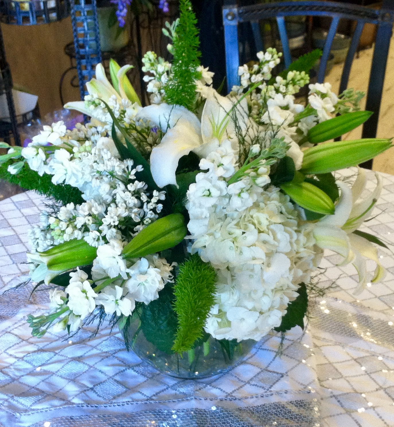 White floral arrangement with lilies and hydrangea in a glass vase