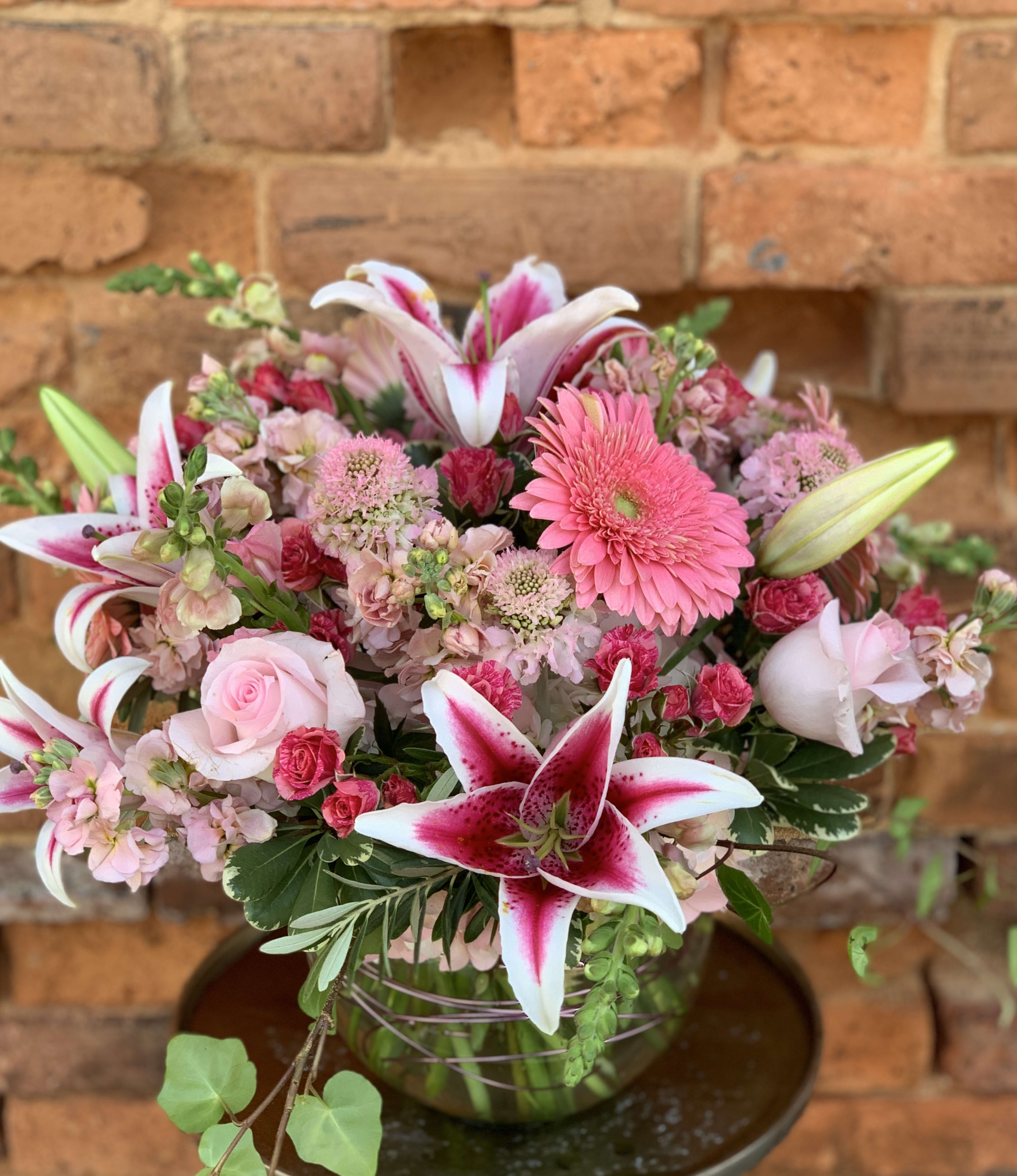 Pink and white mixed flower arrangement in a glass vase