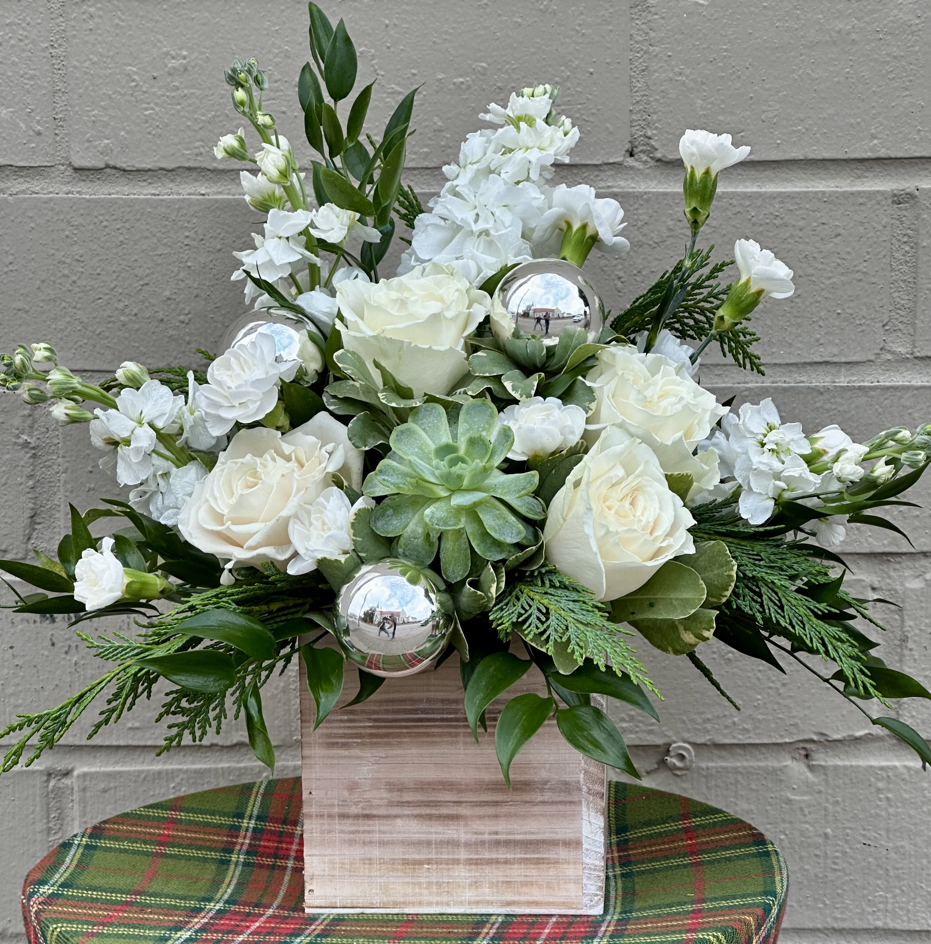 White roses and carnations in a wooden box with silver ornaments