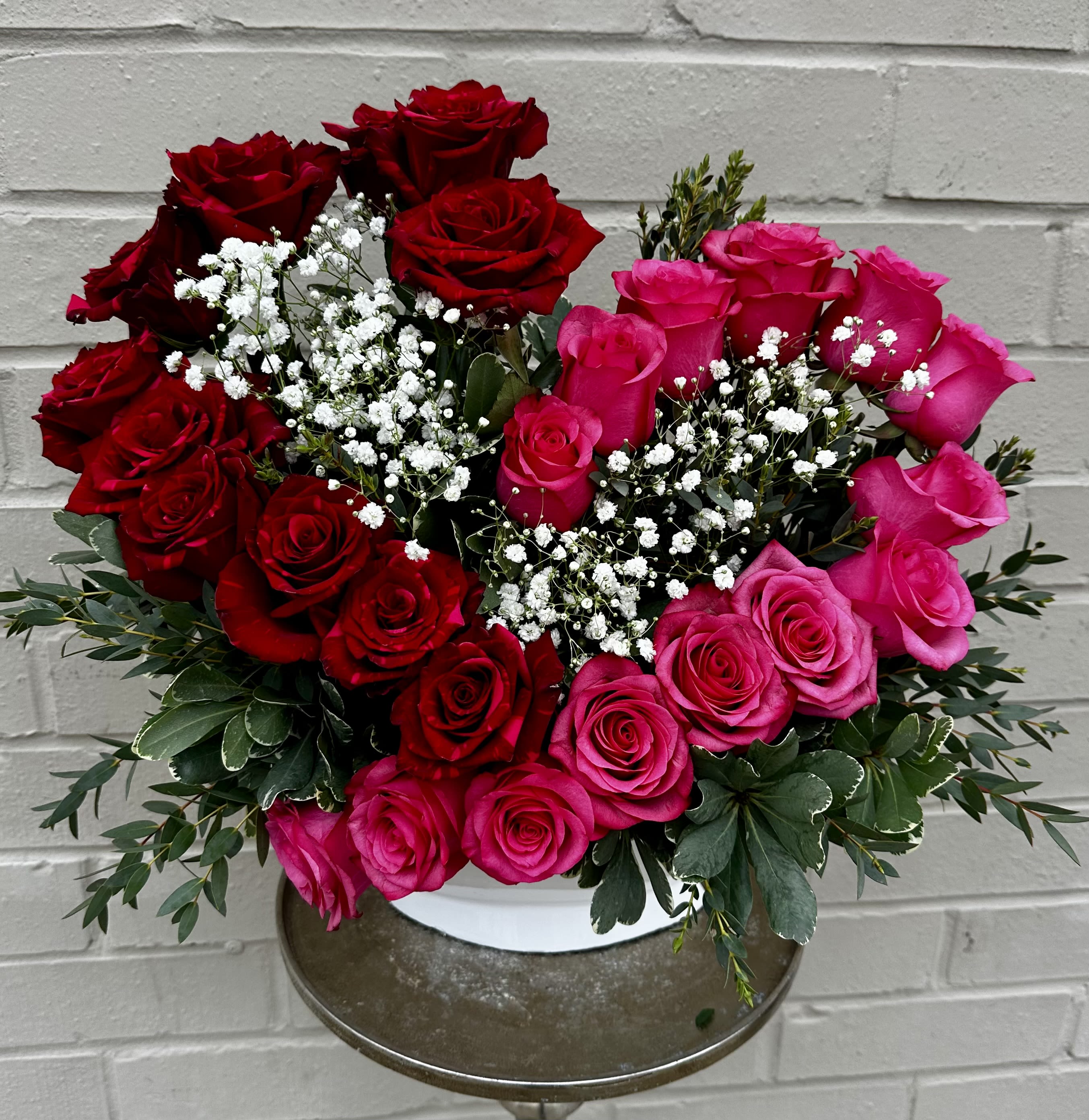 Bouquet of red and pink roses with white baby's breath in a vase