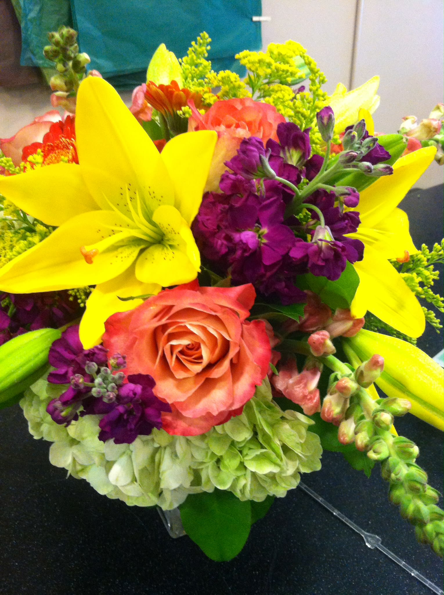 Bouquet with yellow lilies, coral roses, and purple flowers