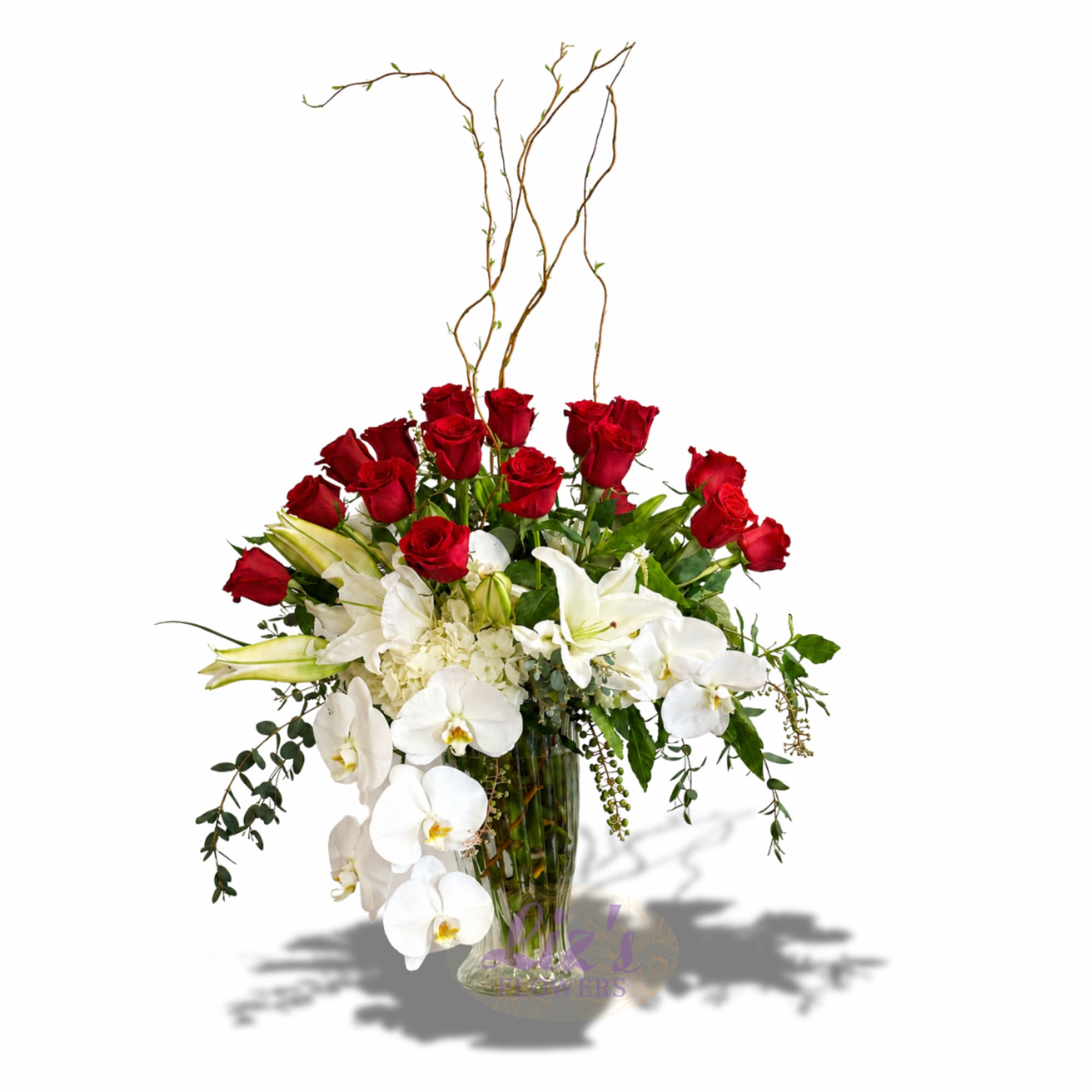 The Crimson Cascade Vase - We’ve paired vibrant red roses with fragrant white lilies and elegant, cascading orchids, then finished it off with curly willow and lush greenery. It’s the perfect centerpiece for anniversaries, big celebrations, or whenever you really want to impress.