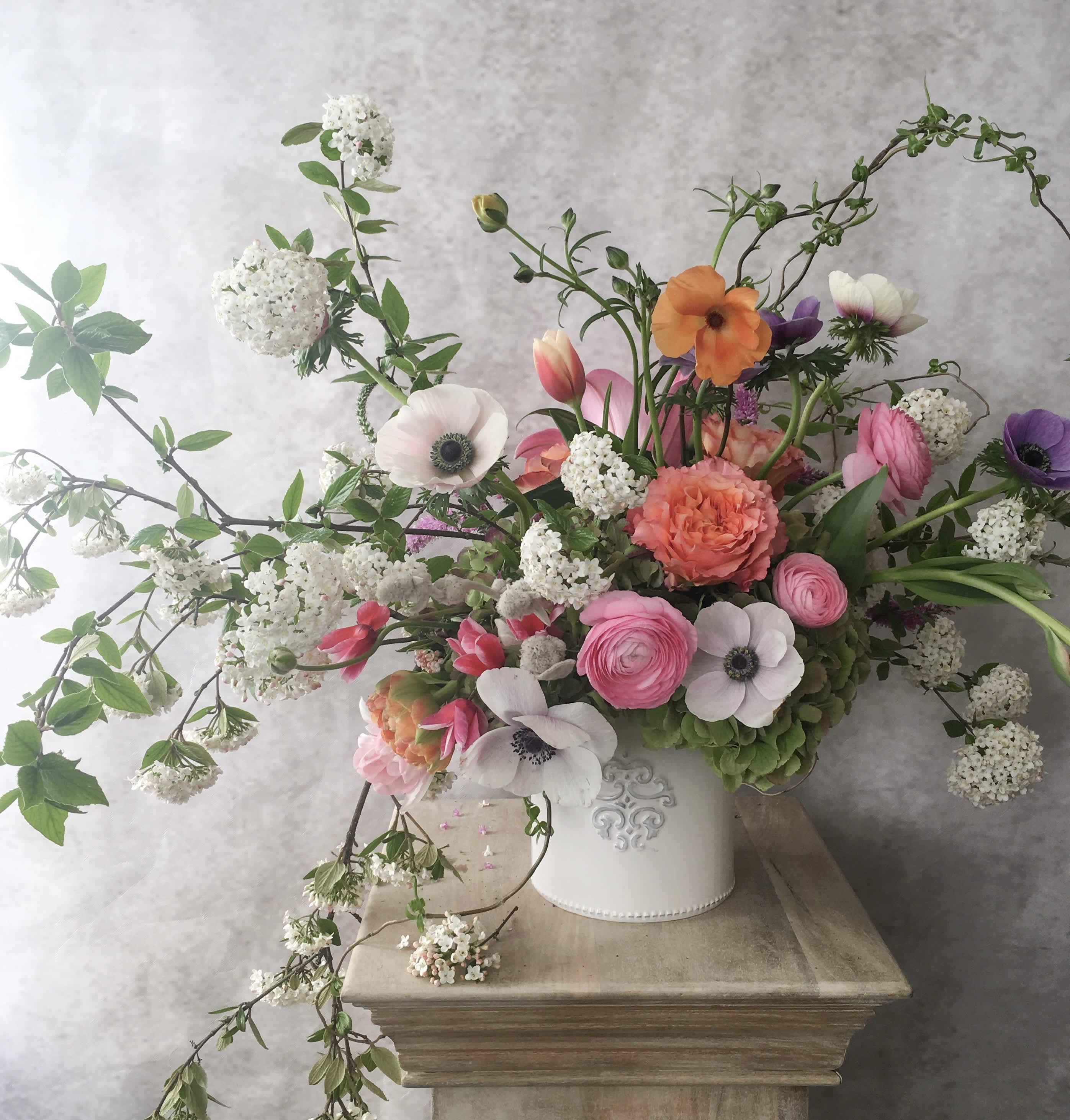 Mixed bouquet in a white vase with pink, orange, purple, and white blooms
