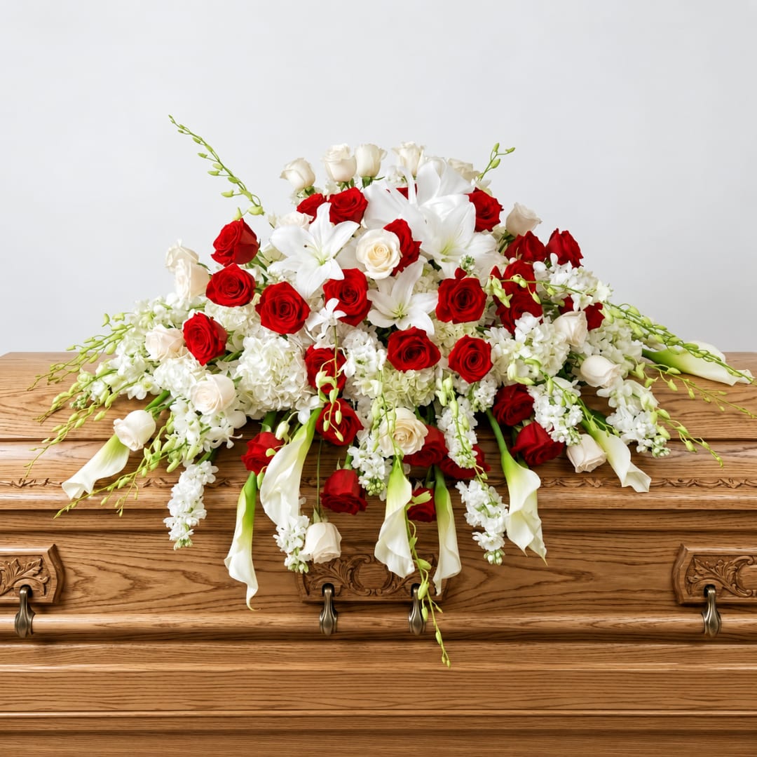 Red and white floral spray on a wooden casket