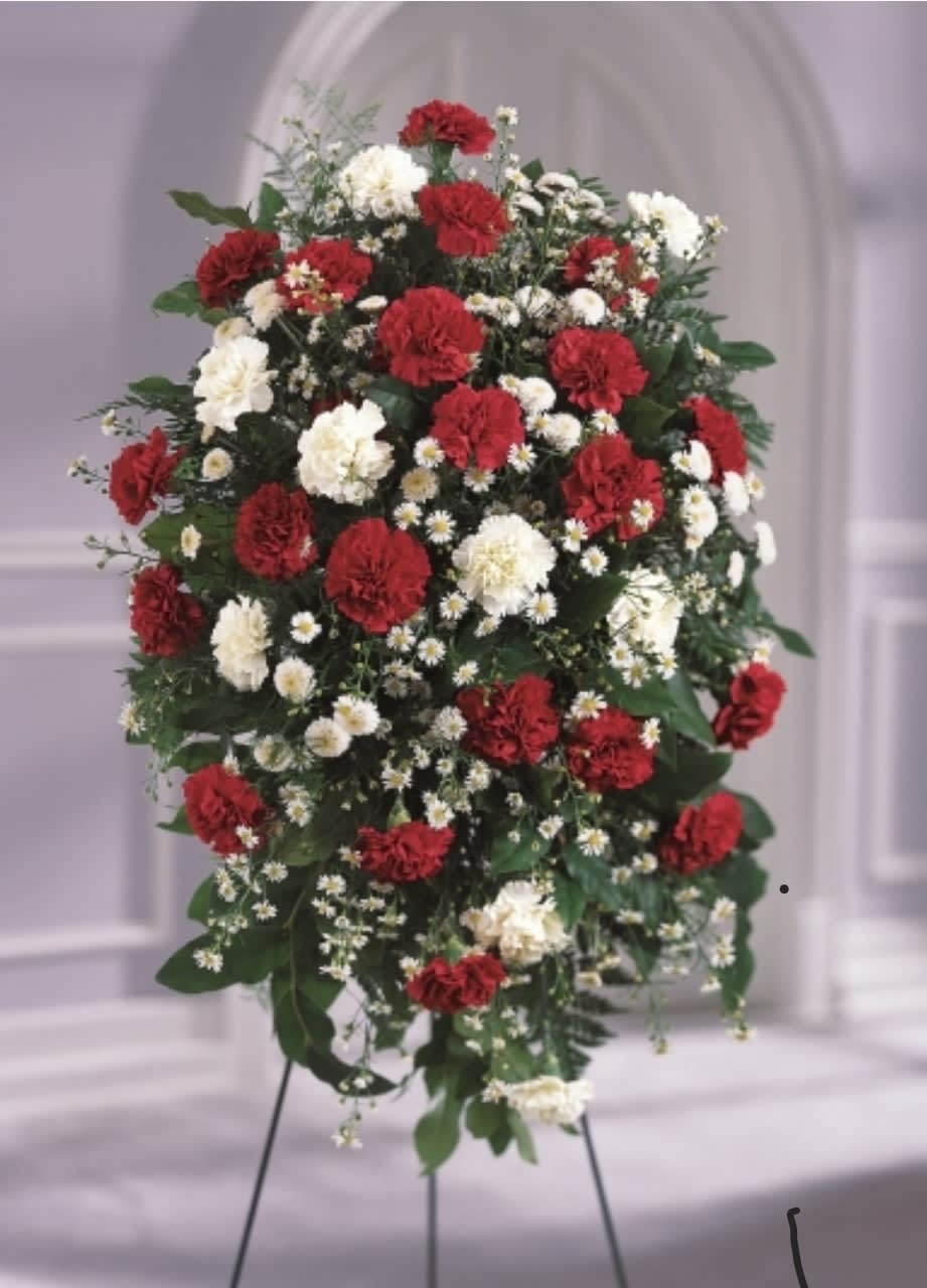 Standing floral spray with red and white carnations on a tripod easel