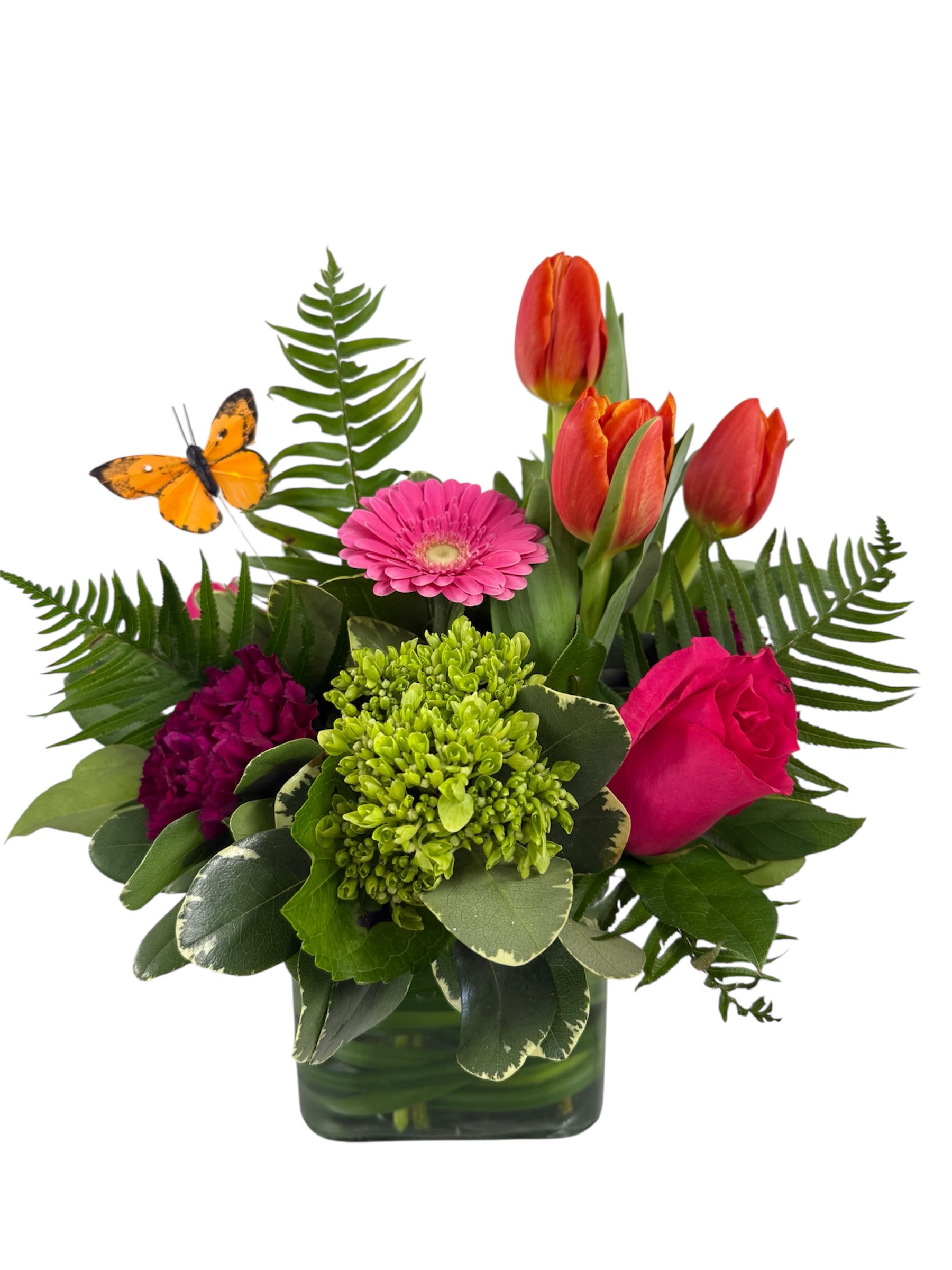 Mixed bouquet in a square glass vase with tulips, a gerbera daisy, and a rose