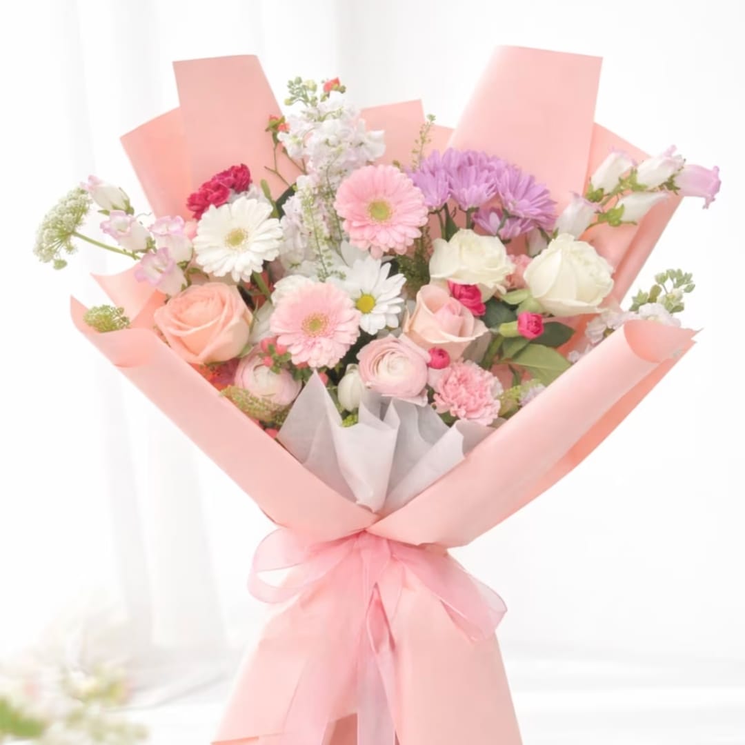 Pink and white mixed flower bouquet wrapped in pastel pink paper