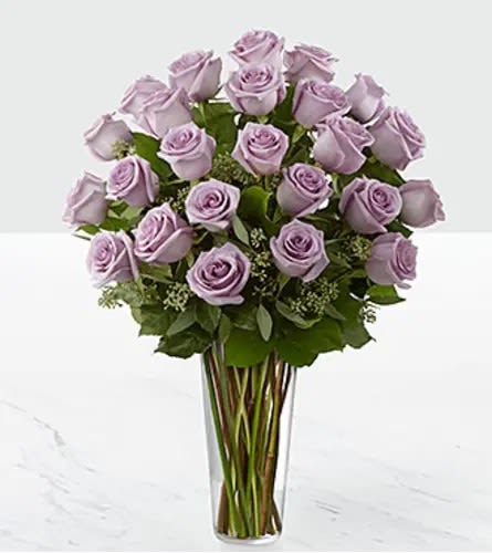 Lavender roses arranged in a clear glass vase