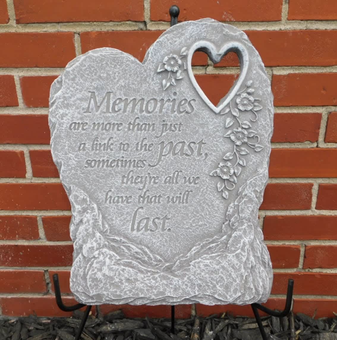 Heart-shaped memorial stone with floral decoration and engraved text