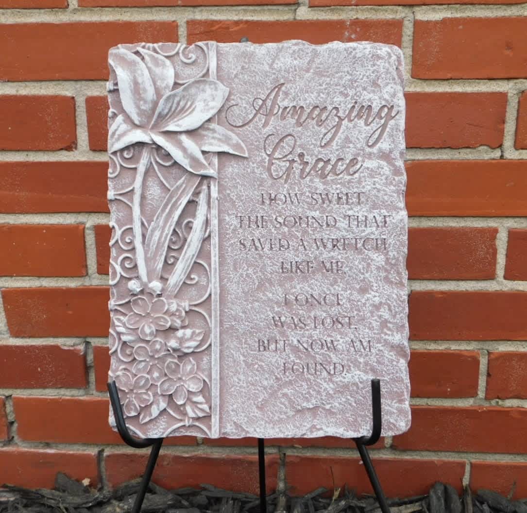 Decorative stone plaque with floral relief and the words "Amazing Grace"
