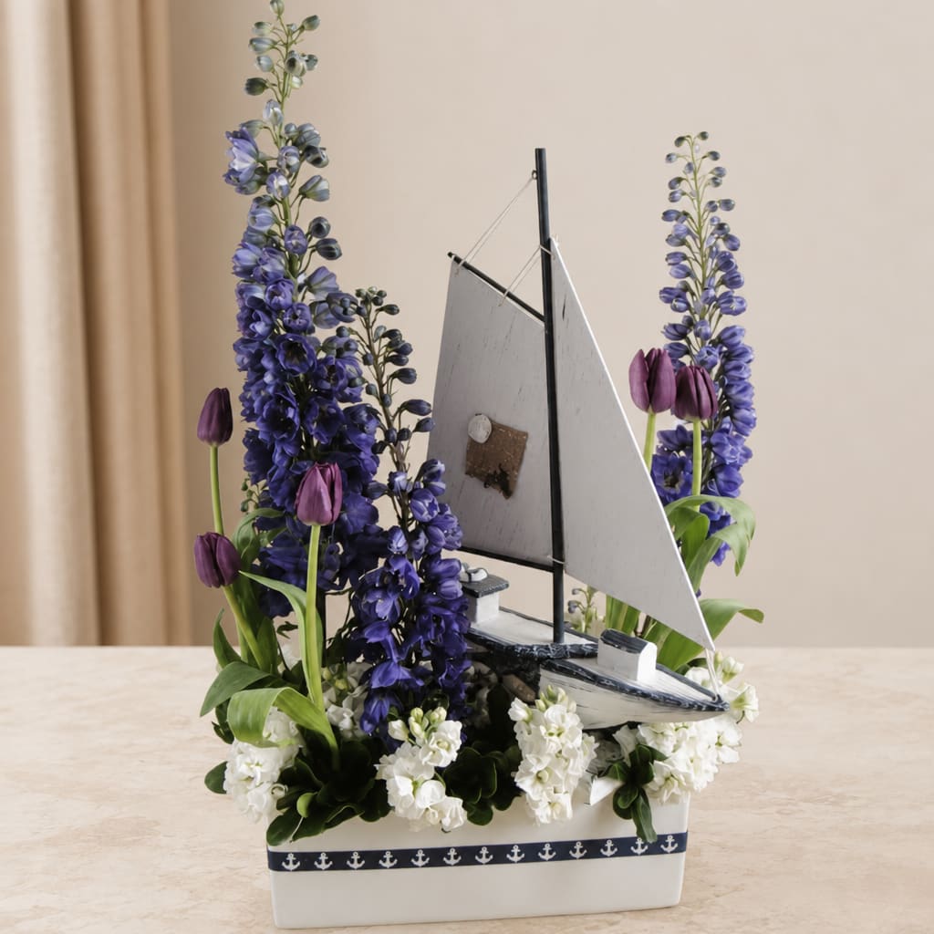 Sailboat centerpiece with purple flowers and white blooms in a white container