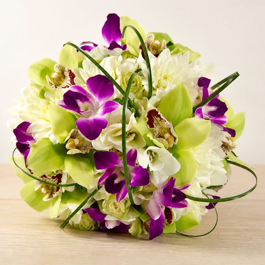 Purple orchids and white flowers arranged in a round bouquet