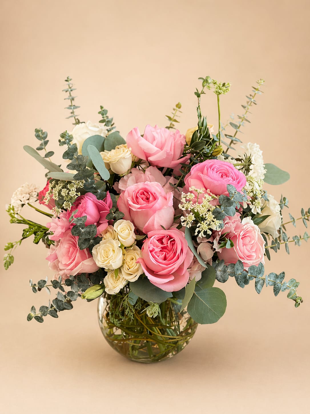Rose Quartz Heart  - Flowers: pink xpression garden roses, white spray roses, pink ranunculus, frutetto roses, white scabiosa, orlaya flower, babye blue eucalyptus, and silver dollar eucalyptus.   Arranged in a small fishbowl glass vase decorated with curly willow