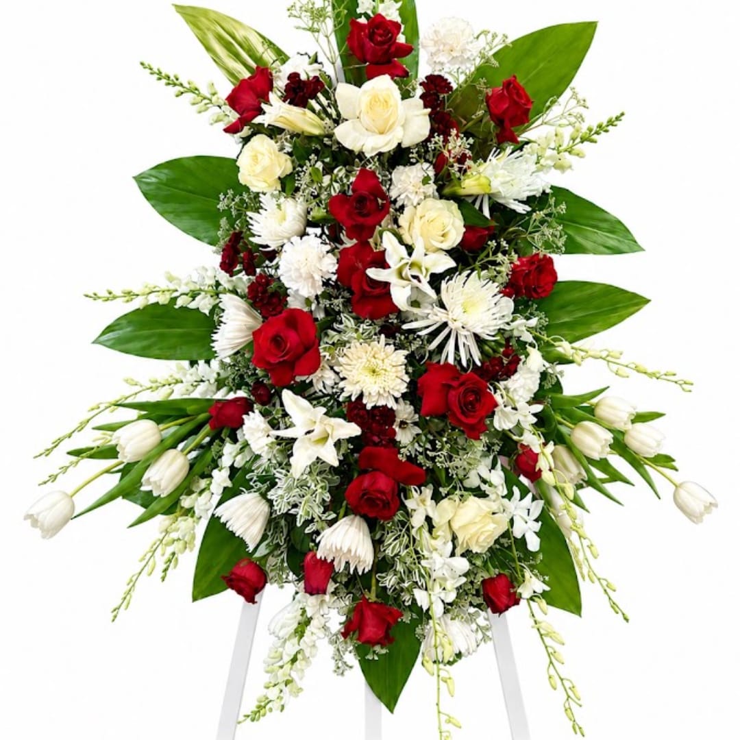 Standing floral spray with red and white flowers on a white easel