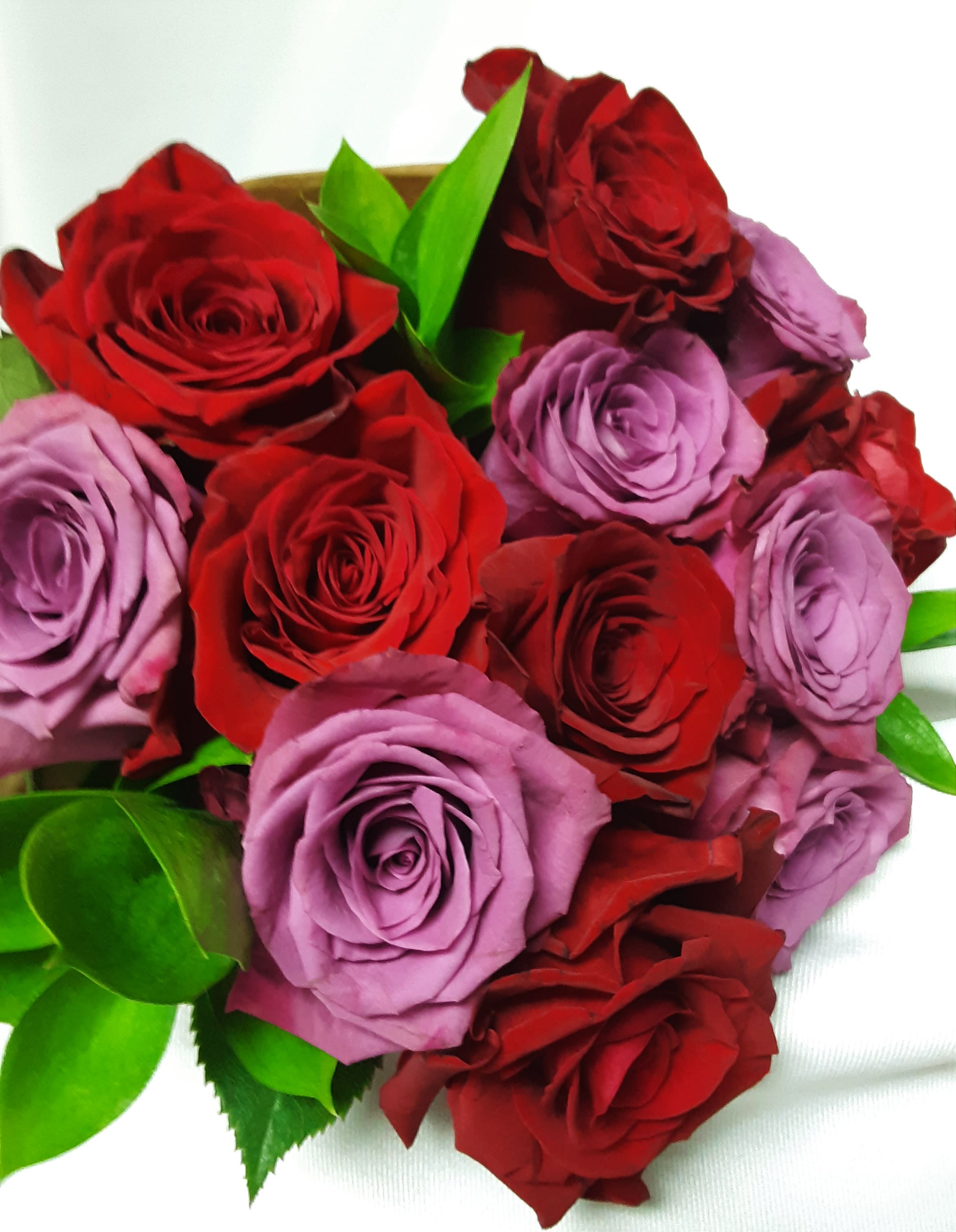 Bouquet of red and lavender roses with green leaves