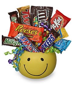 Smiley-face container filled with assorted candy bars and curly ribbon