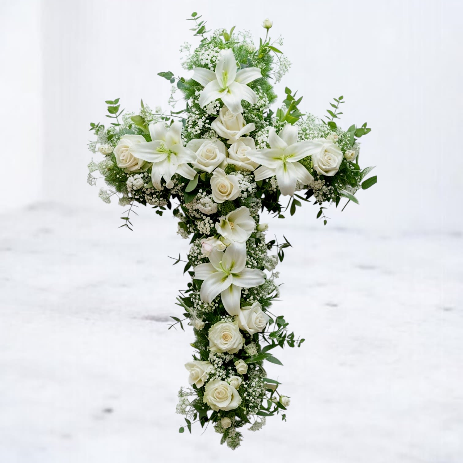 Faith - An all white tribute, this white cross funeral spray is pure and tranquil. Featuring a variety of white flowers, this elegant easel compliments the beauty of life. 