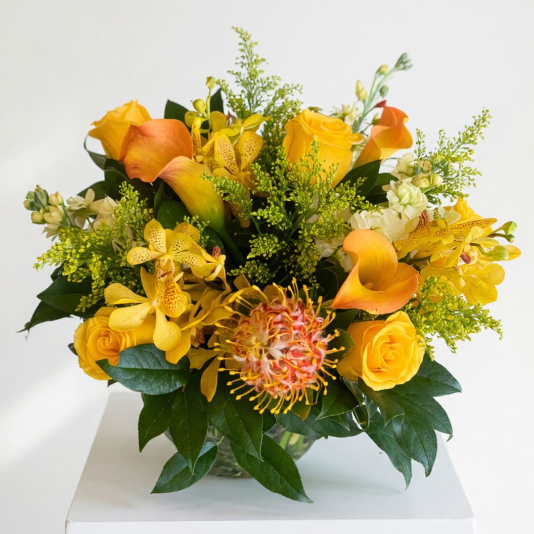 Yellow and orange floral arrangement in a glass vase