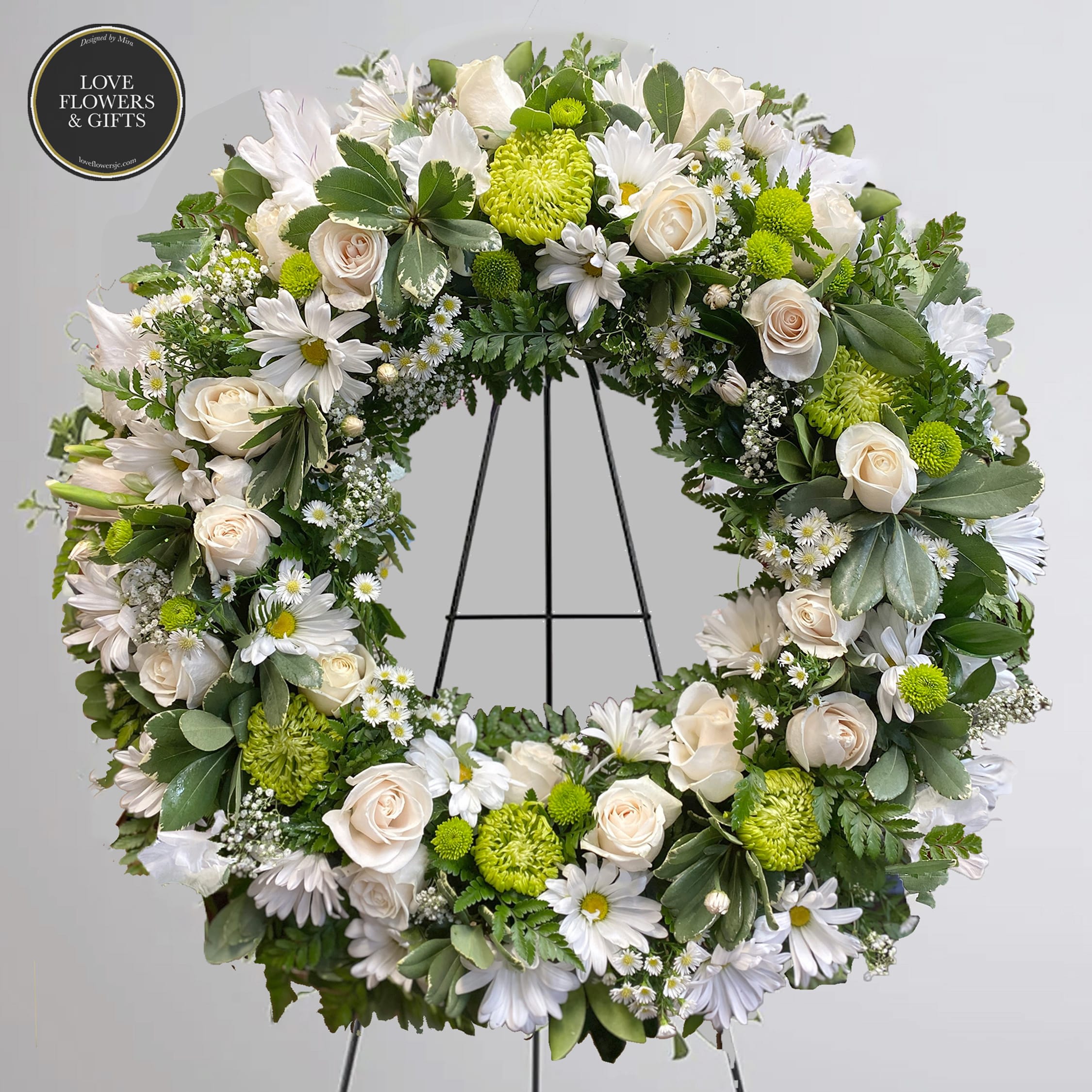 Lasting Serenity (Standing Round Wreath)  - Send your condolences and pure hearts with this beautiful white and green round wreath on easel. 