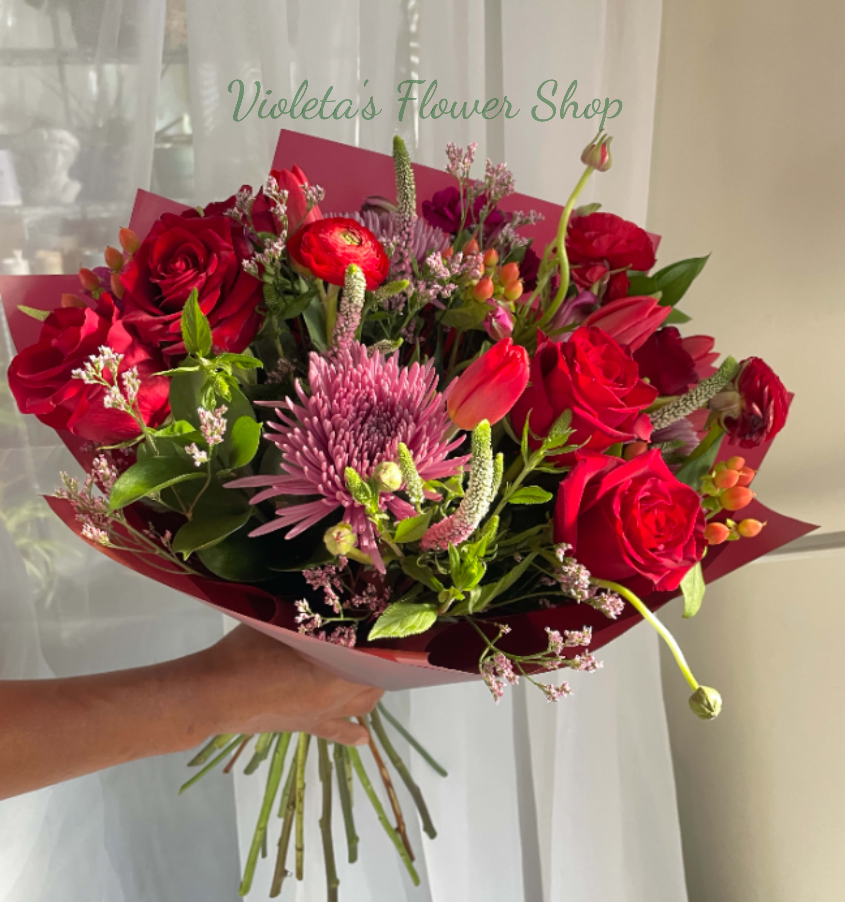 In Love With You Bouquet - Velvety red roses paired with tulips and a large lavender-pink chrysanthemum-like bloom create an immediately romantic centerpiece - an anniversary bouquet that also reads perfectly for love and romance or a "thinking of you" surprise. The rich burgundy wrapping paper frames the saturated reds and gentle pinks, giving the hand-tied arrangement a luxurious, intimate feel that will make the person you're thinking of feel truly seen and celebrated. Perfect for anniversaries, romantic gestures, Valentine's Day, or a thoughtful everyday surprise, this bouquet says "I love you" with depth and warmth. To keep blooms fresh longer, treat with fresh water and trim stems; available to order for same-day local delivery when placed early in the day.