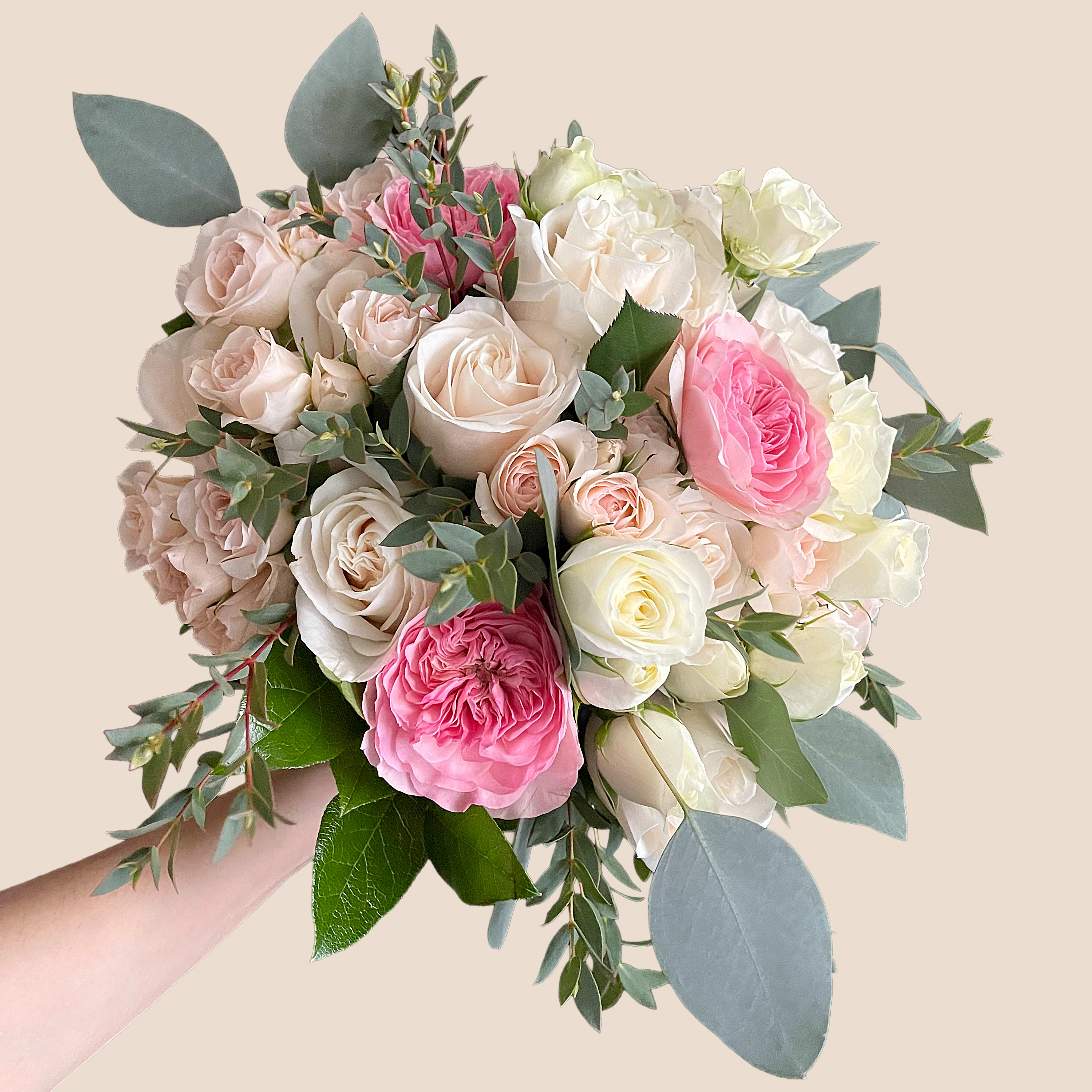 Handheld bouquet of pink and white roses with eucalyptus