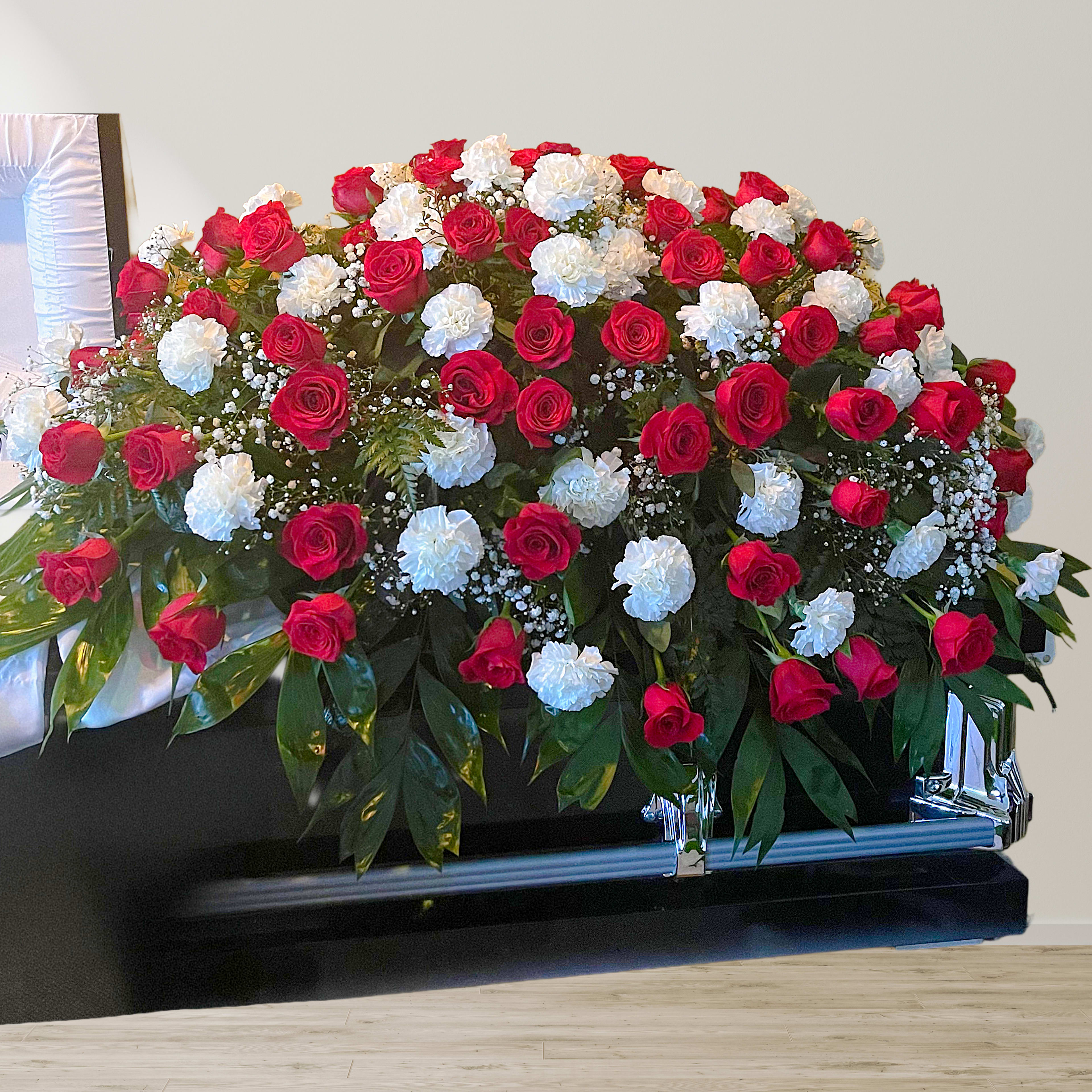 Red and white rose casket spray with greenery