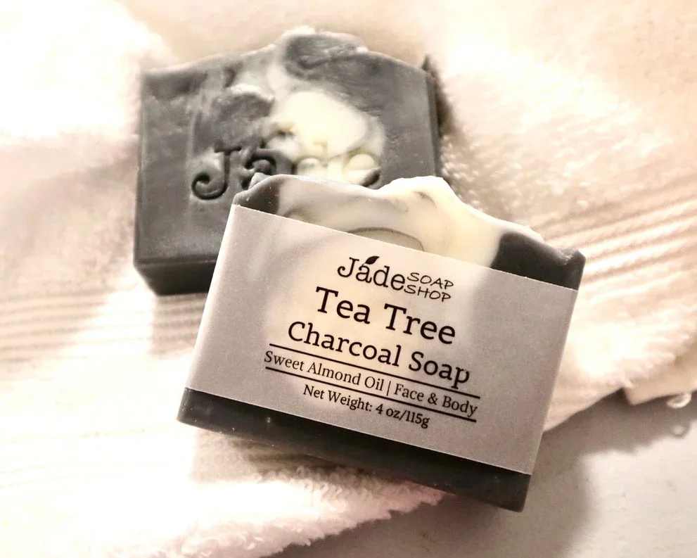 Black and white marbled tea tree charcoal soap bars on a white towel