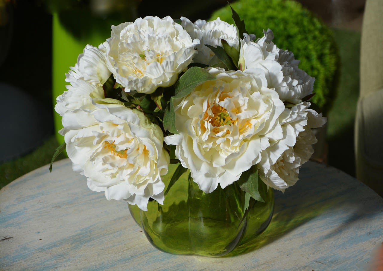 White peony bouquet in a green glass vase