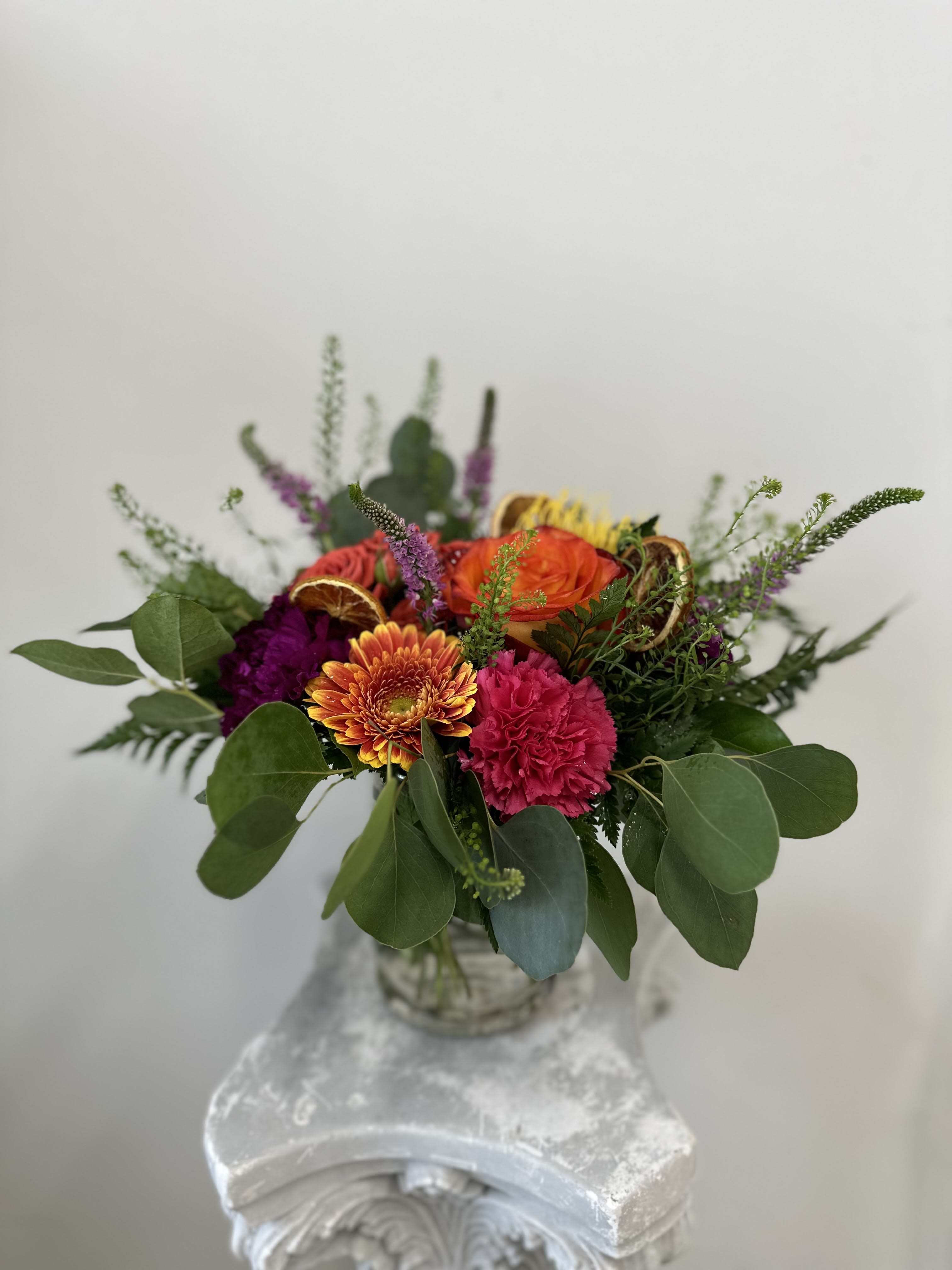 Blooms for you by Westford Florist Art by Veny - Elevate your floral gifting experience with *Blooms for You* by Westford Florist Art by Veny. This exquisite arrangement showcases a vibrant blend of stunning proteas, striking orange roses, delicate spray roses, and cheerful orange gerbera daisies. The addition of elegant veronica flowers introduces a delightful texture complemented by hot pink and magenta carnations, while aromatic dry orange slices bring warmth and cheer to the ensemble. Enhanced with a lush mixture of greenery, this thoughtfully curated bouquet is perfect for any occasion—be it celebrations or simply brightening someone’s day. Discover the artistry of nature in every bloom.