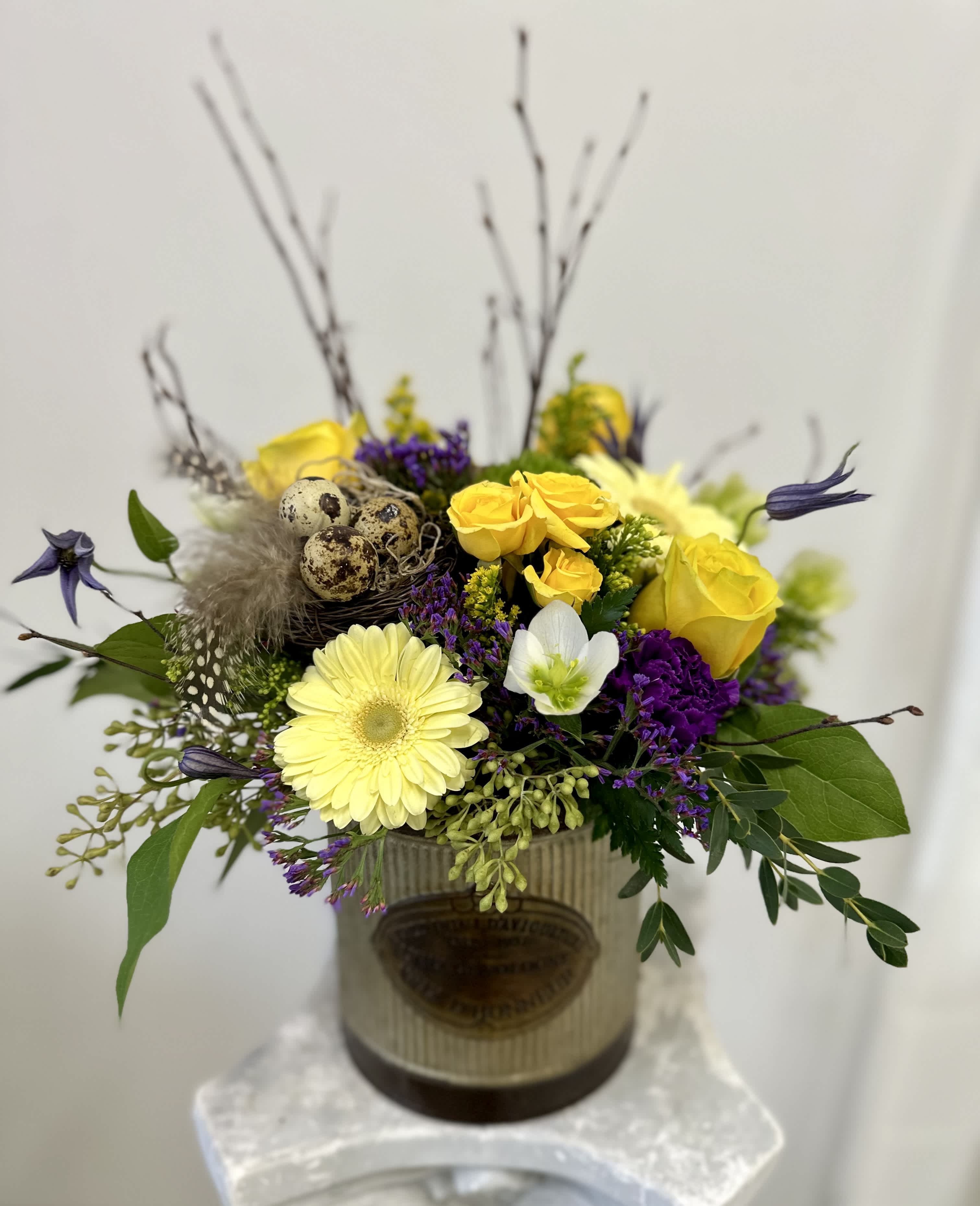 Spring Vibes by Westford Florist Art by Veny - Indulge in the opulence of Spring with exquisite Spring Vibes flower arrangement by Westford Florist Art by Veny. Picture yourself surrounded by the beauty of fresh yellow and purple blooms, elegantly displayed in a rustic tin container adorned with lush greenery. But that's not all- this luxurious arrangement is topped off with delicate guinea fowl feathers nestled within a charming nest. Elevate your surroundings and create a sense of renewal with this stunning floral masterpiece. Whether you're looking to refresh your home or office space, or simply seeking inspiration during this magical time of year, our Spring Vibes arrangement is sure to bring joy and vibrancy to any setting. Embrace the essence of springtime luxury and treat yourself to something truly special. Order your Spring Vibes flower arrangement by Westford Florist today and bask in the beauty of nature's finest creations.  