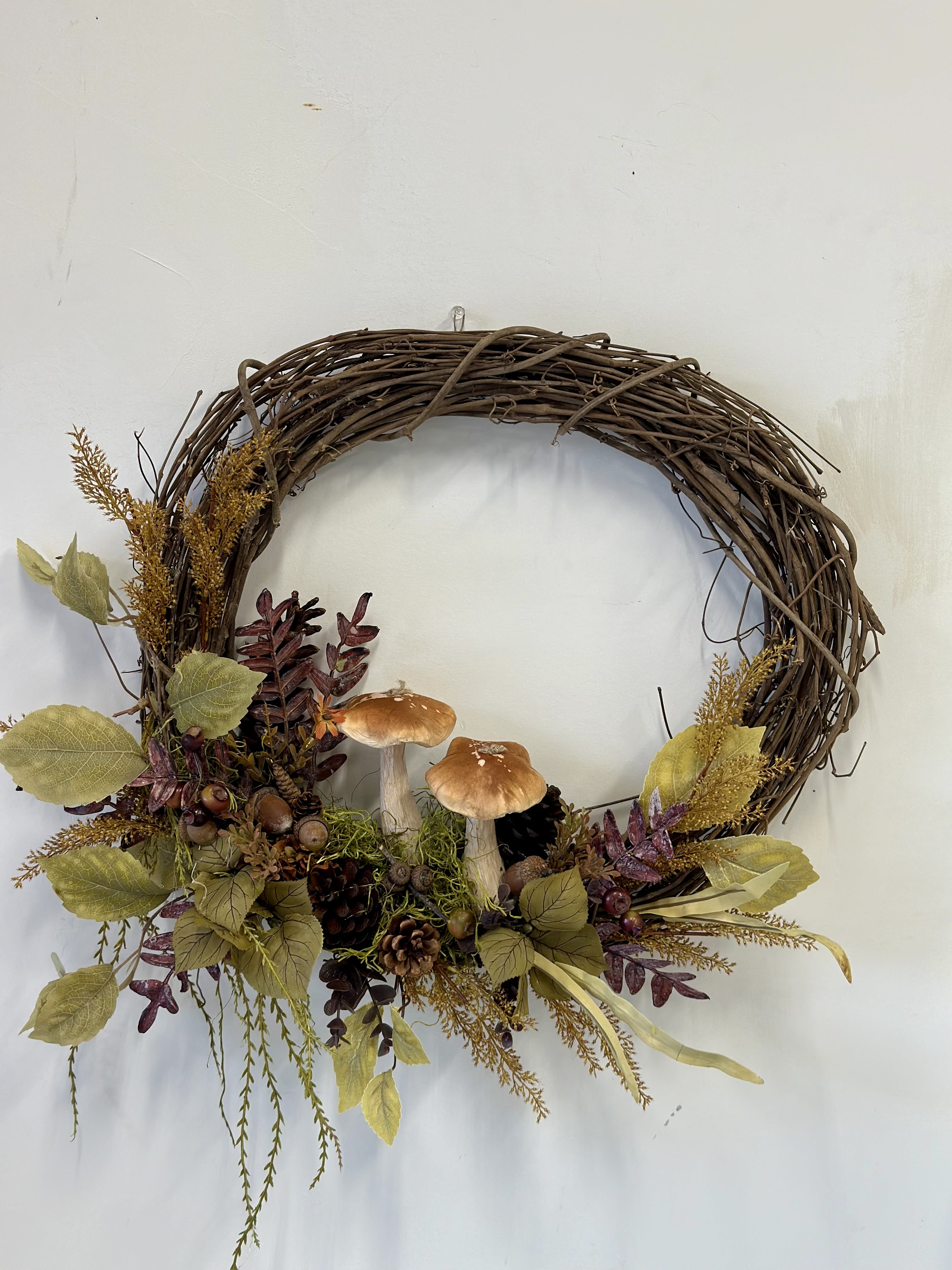 Fall Harvest Silk Wreath b Westford Florist Art By Veny - Embrace the beauty of autumn with our exquisite Fall Harvest Silk Wreath by Westford Florist Art by Veny. Crafted from a rich blend of vibrant seasonal foliage, this stunning décor piece captures the essence of harvest time, featuring warm hues of orange, deep reds, and rustic browns. Measuring approximately 20" in diameter, each wreath is meticulously designed to bring a touch of nature's splendor to your doorstep or living space. Perfect for enhancing both indoor and outdoor settings, this silk wreath ensures durability while effortlessly celebrating the charm of the season year after year. Elevate your autumn décor with this elegant statement piece that invites warmth and nostalgia into your home.