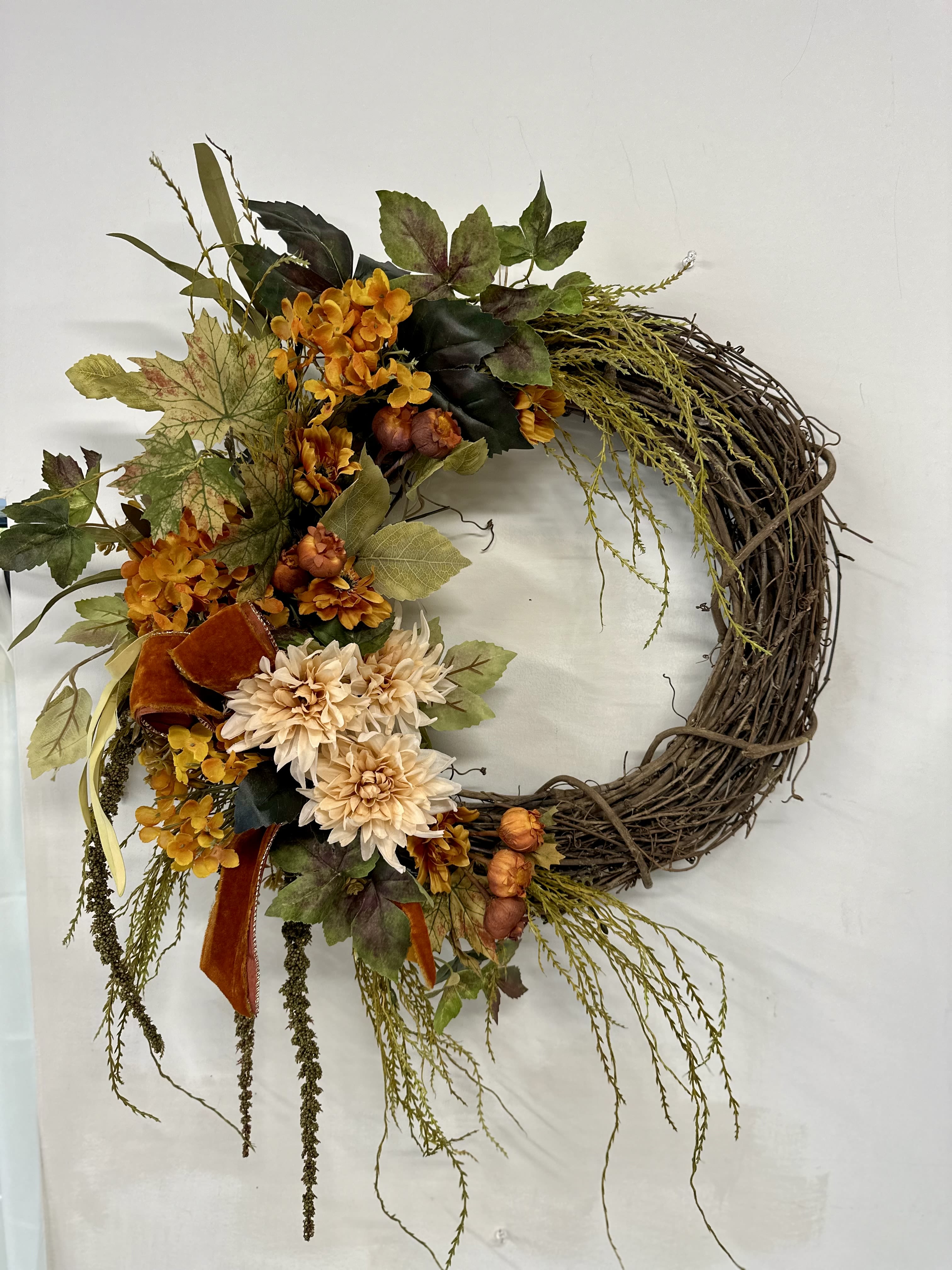 Rustic Elegance Silk Wreath by Westford Florist Art by Veny - Embrace the beauty of autumn with the Rustic Elegance Silk Wreath by Westford Florist Art by Veny. Meticulously crafted from a rich blend of vibrant seasonal foliage, this stunning décor piece captures the essence of harvest time through warm hues of orange, deep reds, and rustic browns. Perfectly sized at approximately 22 inches in diameter, it effortlessly enhances your doorway or living space, inviting warmth and charm into your home. Celebrate the season's richness and create an inviting atmosphere that reflects both style and sophistication. Elevate your décor with this timeless accent that speaks to nature’s splendor.