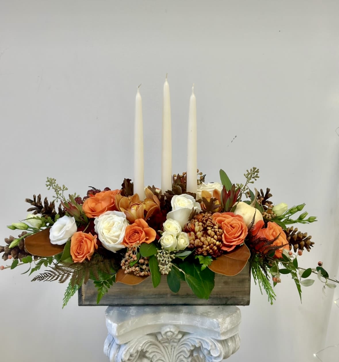 Rustic Chic Premium Thanksgiving Centerpiece by Westford Florist Art by Veny - Elevate your Thanksgiving celebration with the Rustic Chic Premium Thanksgiving Centerpiece by Westford Florist Art by Veny. Designed for those who appreciate the finer details, this exquisite arrangement beautifully combines nature's elegance with rustic charm.  This stunning arrangement boasts a perfect fusion of orange and white roses, along with delicate spray roses, safari sunset blooms, and elegant lisianthus. Adorned with stunning orchids, it captures the essence of luxury and warmth, making it an ideal focal point for your holiday gathering. Transform your dining experience into a memorable occasion that dazzles guests and invites heartfelt conversations.  Let this captivating centerpiece radiate sophistication while complementing the spirit of gratitude this season.  Celebrate in style—your table deserves nothing less than perfection.