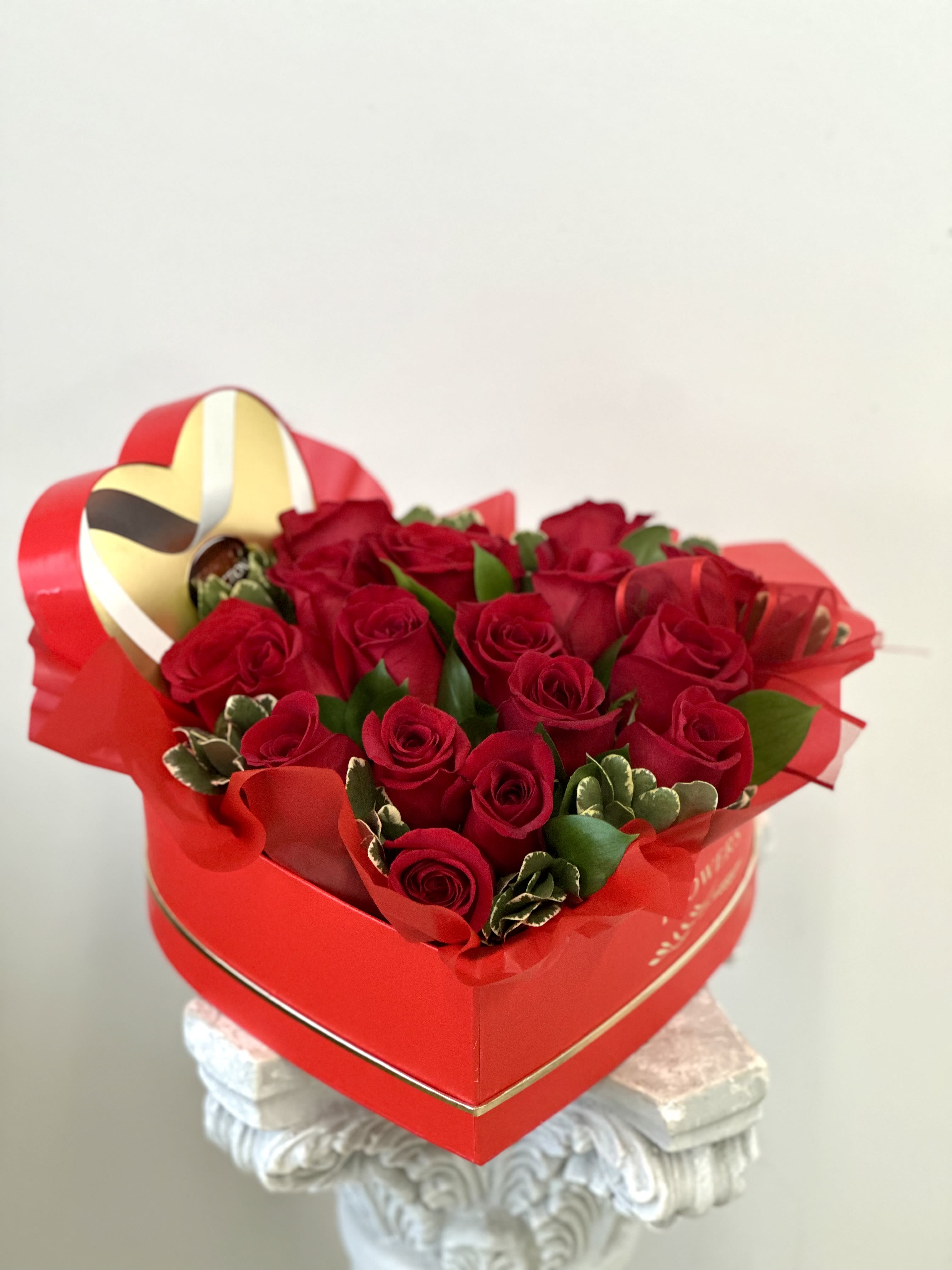 Love's Delight by Westford Florist Art by Veny - Surprise that special someone with a bouquet of love they won’t forget! Love's Delight by Westford Florist Art by Veny is the ultimate Valentine’s Day gift, featuring 16 stunning red roses cradled in a lovely heart-shaped box. Each bloom whispers sweet nothings as it sits pretty beside lush greenery, making it the perfect display of your affection. But that’s not all—because love should always be a treat, we’ve tucked in an irresistible gourmet chocolate box to satisfy their sweetest cravings. Whether it's for a partner or someone who lights up your life, this heartfelt arrangement is sure to make their day unforgettable! 