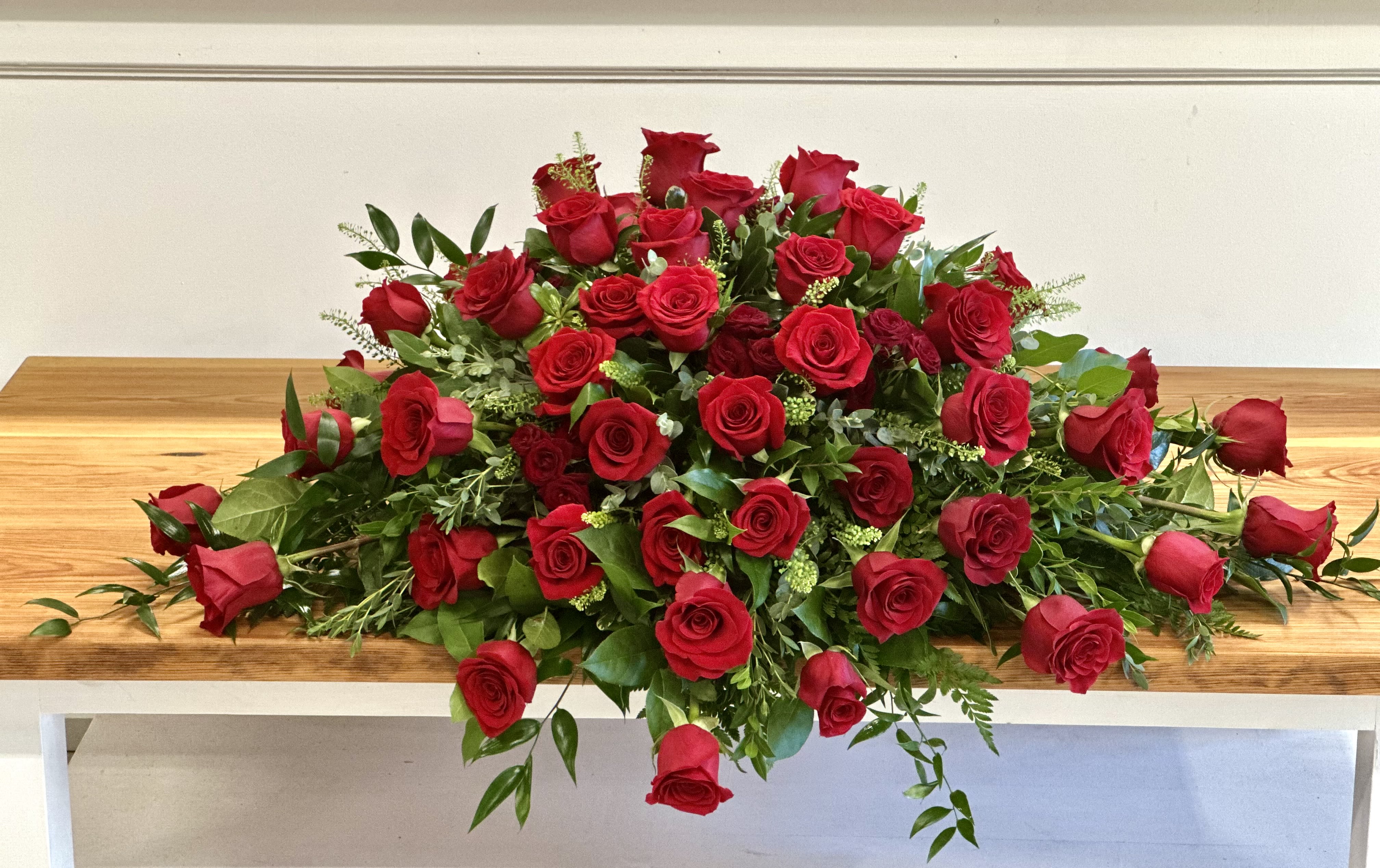 Large arrangement of red roses on a wooden table