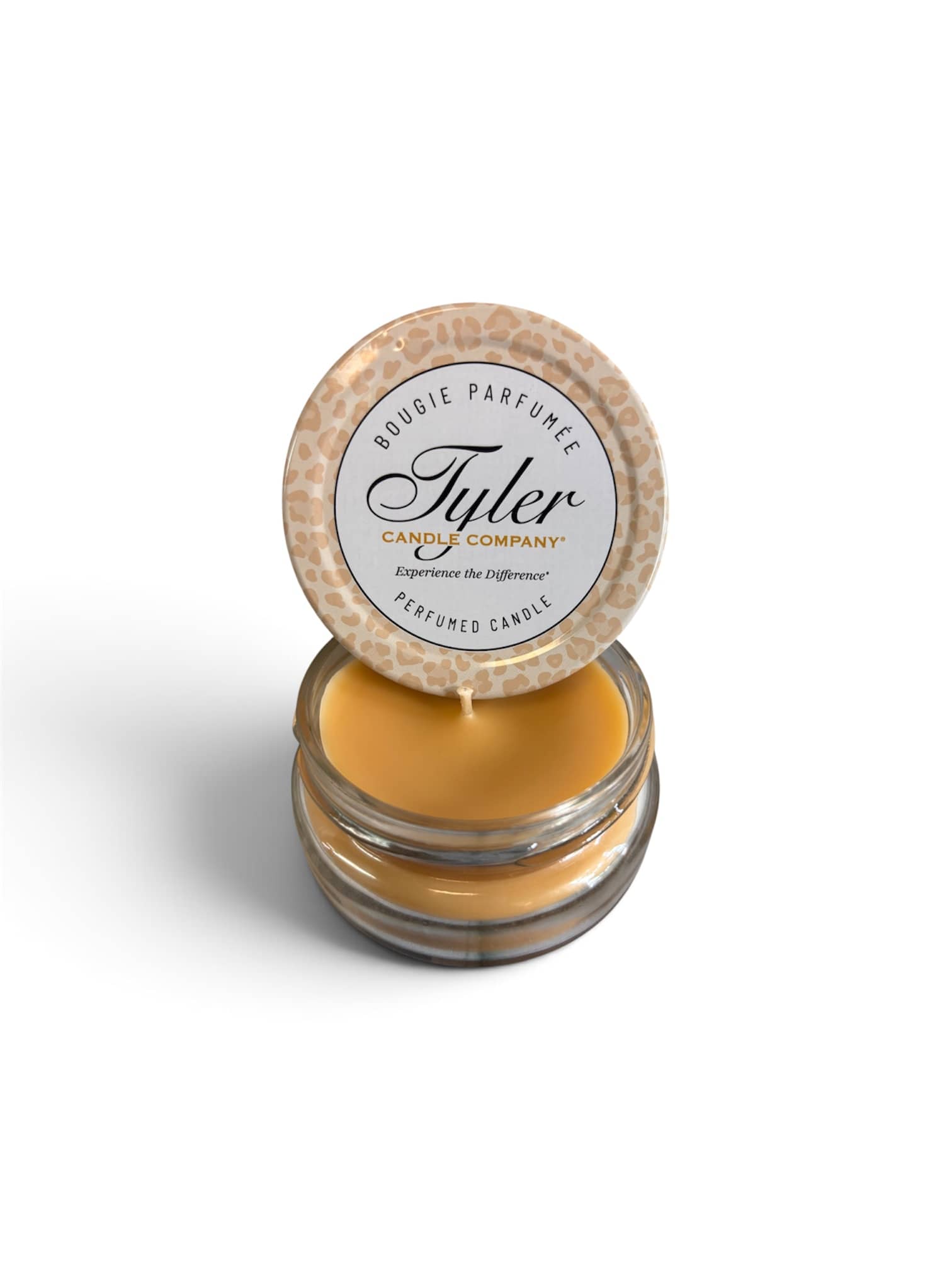 Small amber candle in a glass jar with a patterned lid