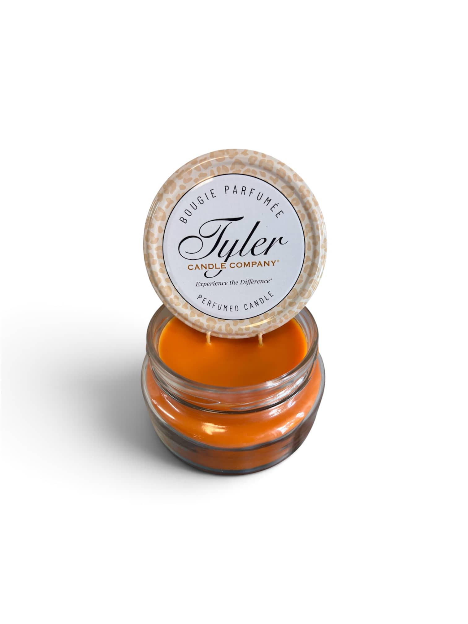 Orange scented candle in a glass jar with a printed lid