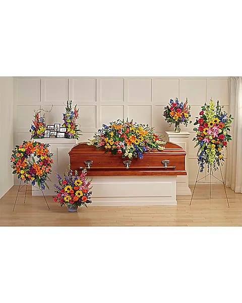 Funeral casket surrounded by colorful floral sprays and arrangements