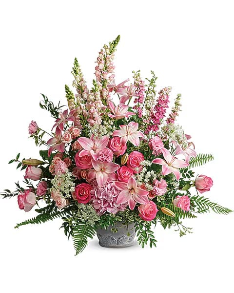 Pink lilies and roses arranged in a gray vase
