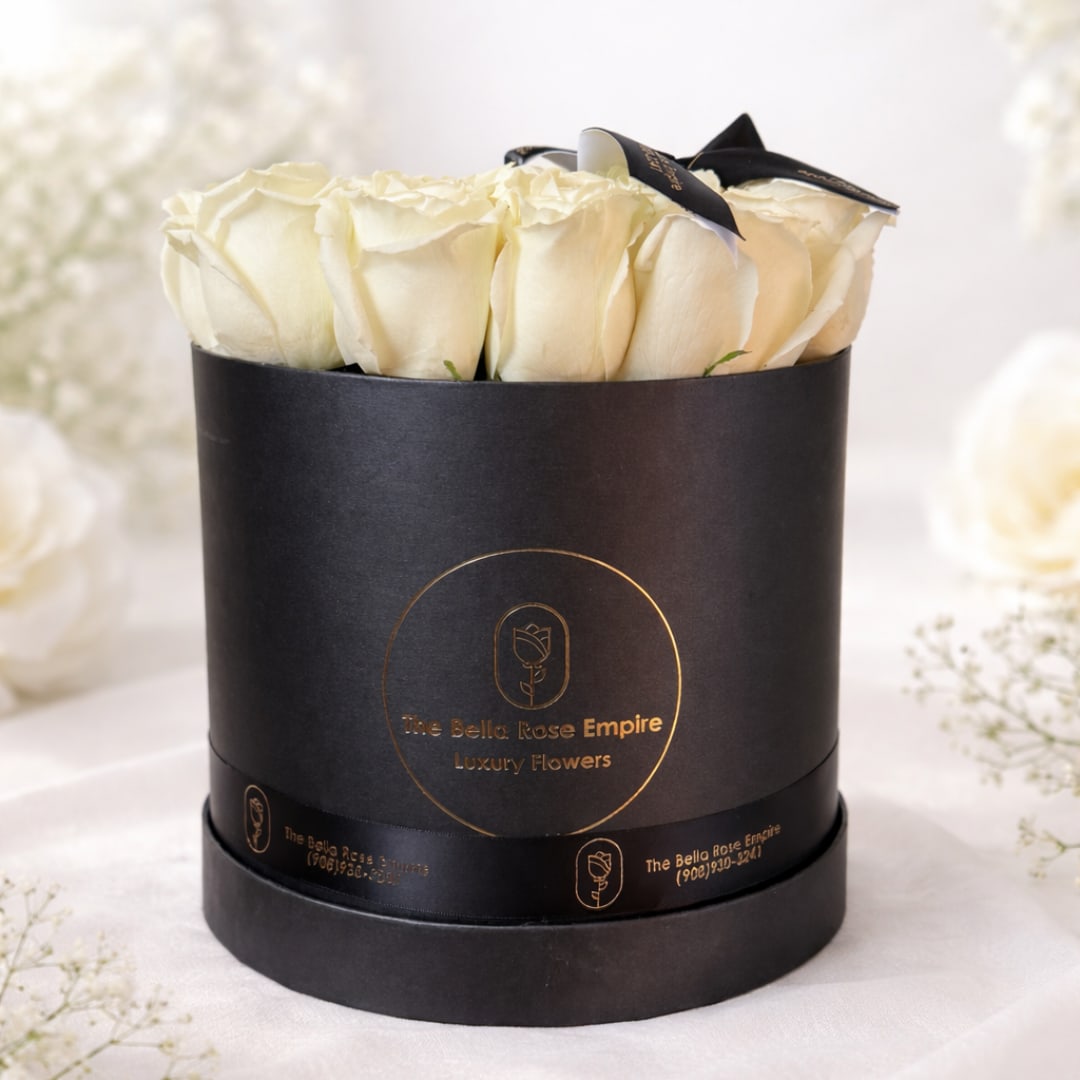 Cream roses arranged in a black round box with a ribbon