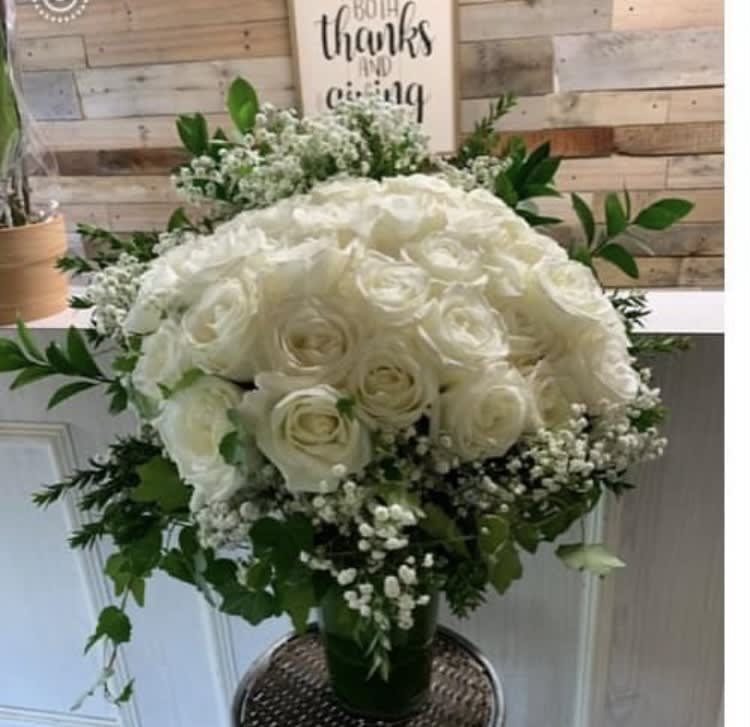 White rose bouquet with baby's breath in a glass vase