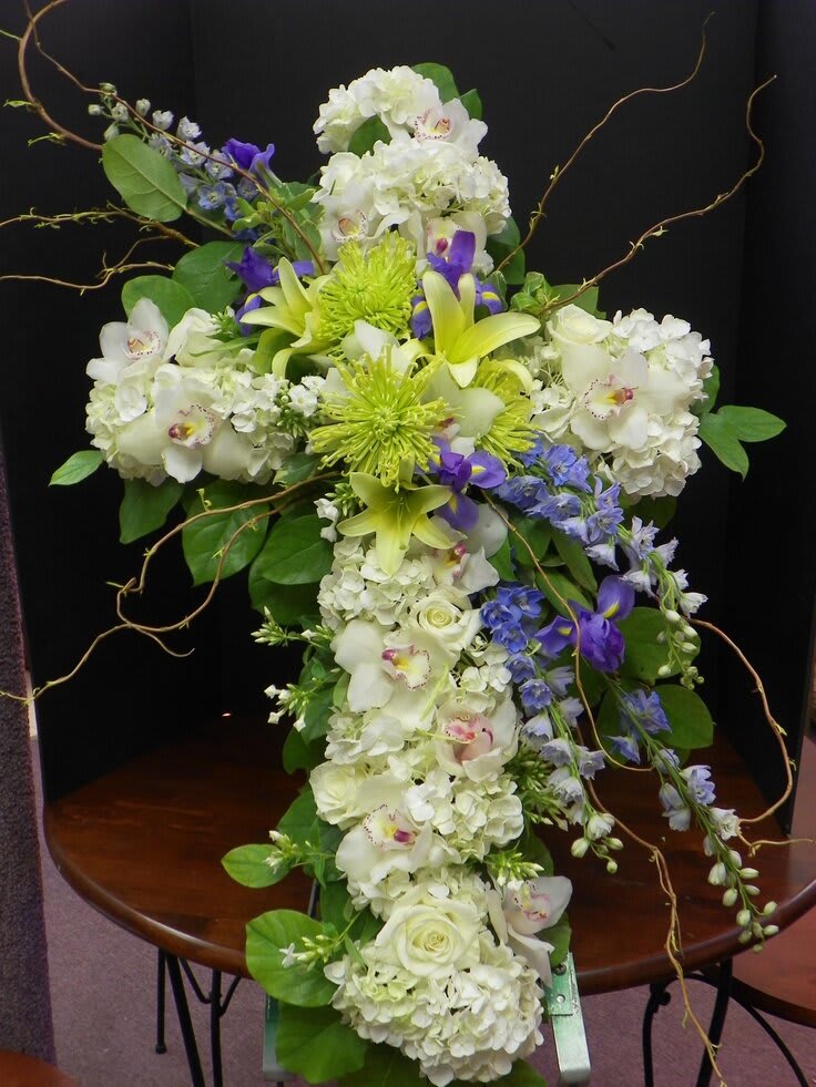 Tall floral arrangement with white, green, and purple blooms