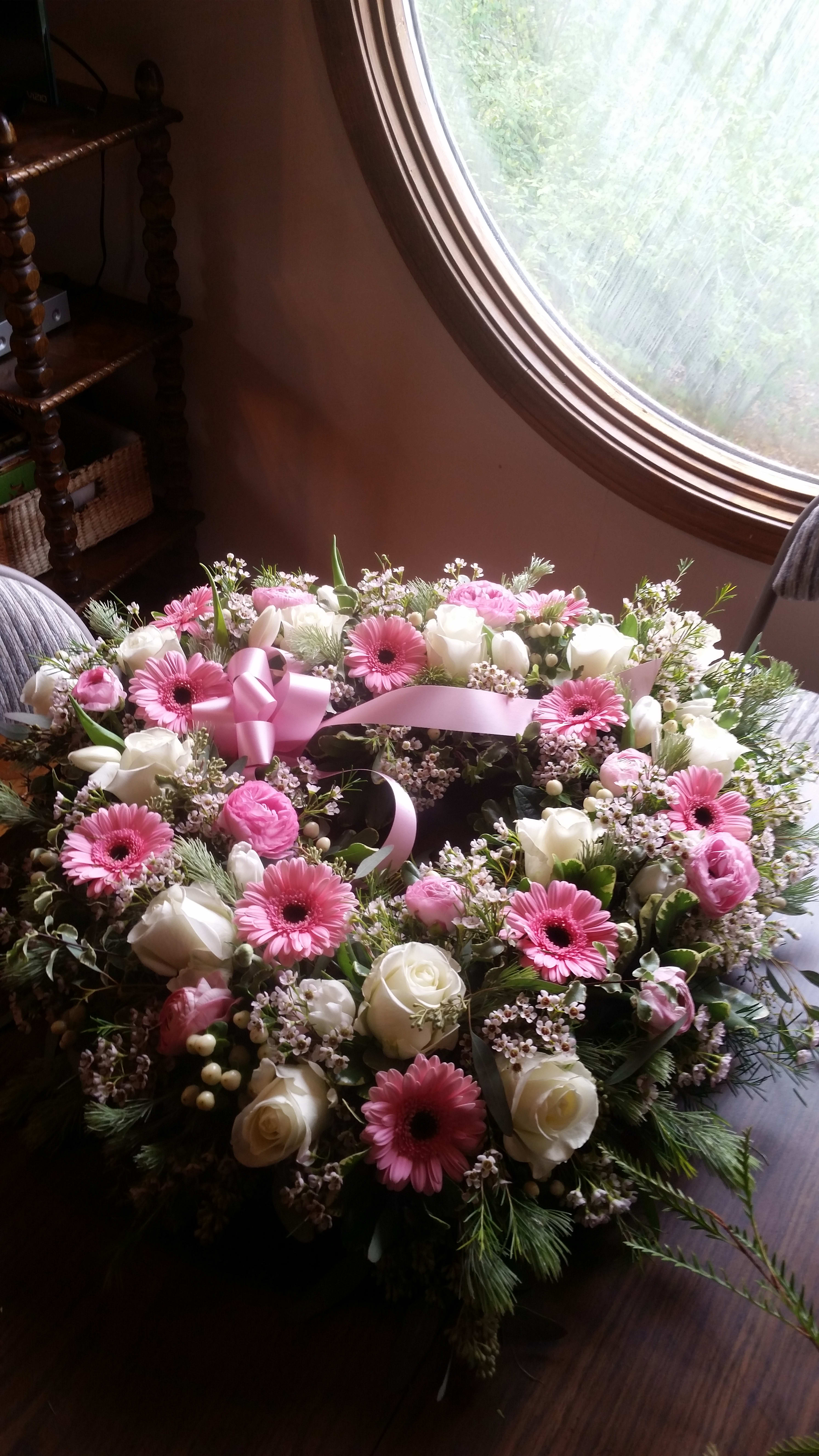 Pink and white floral wreath with a pink ribbon bow