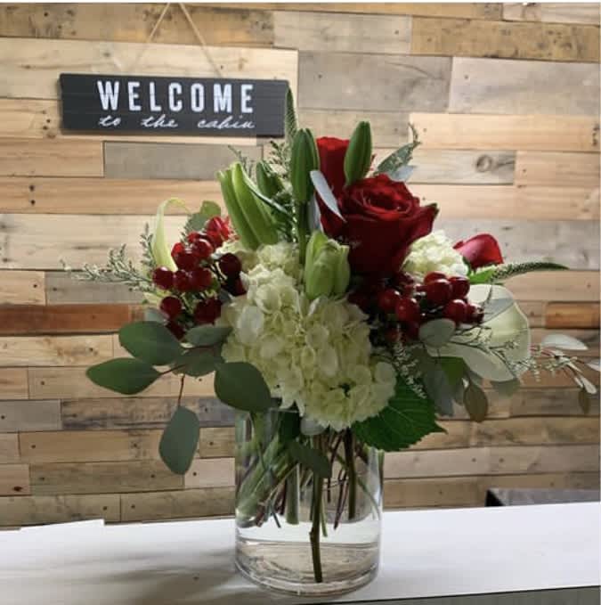 Red roses and white hydrangeas in a clear glass vase
