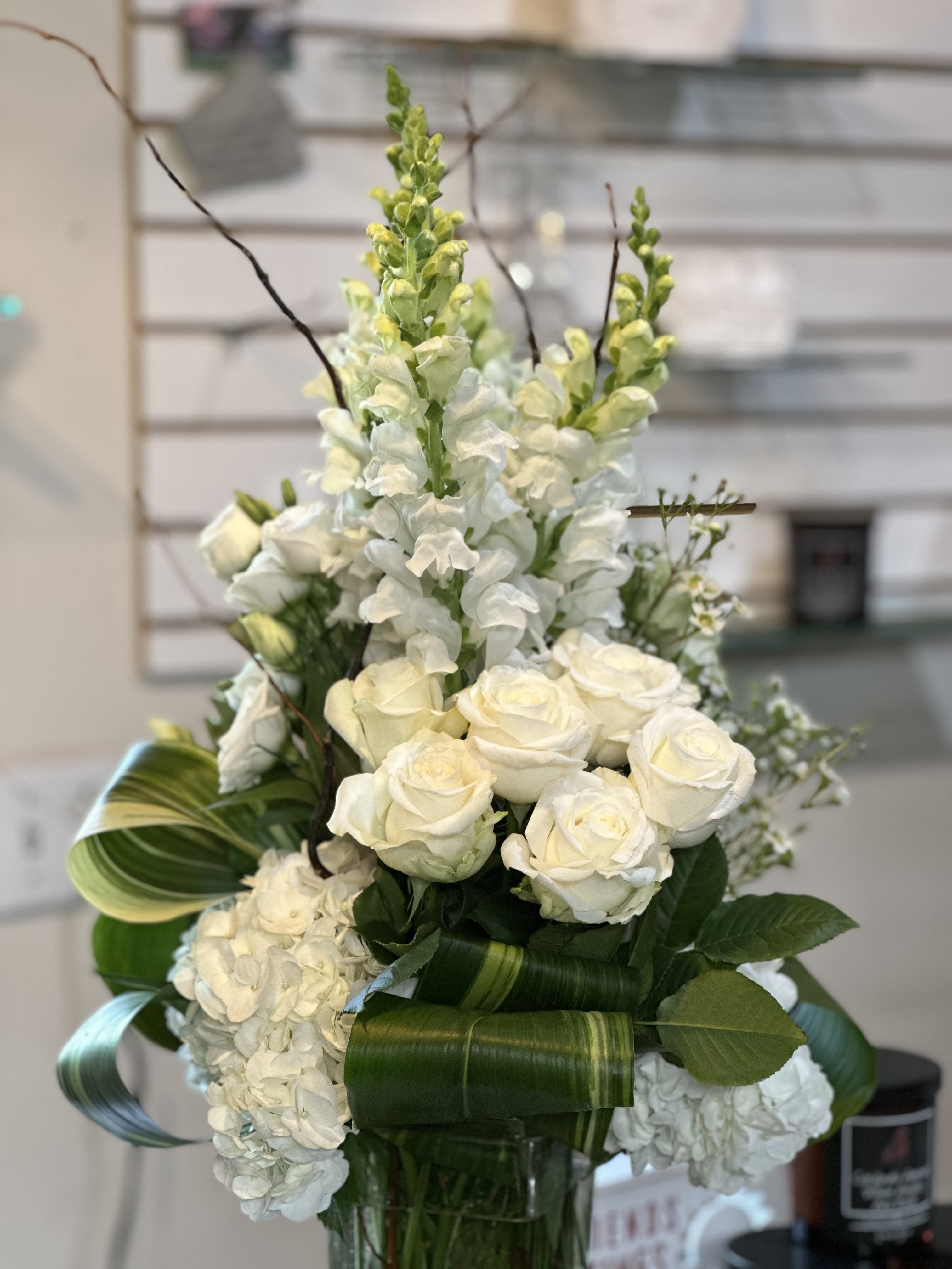 White roses and snapdragons arranged in a glass vase