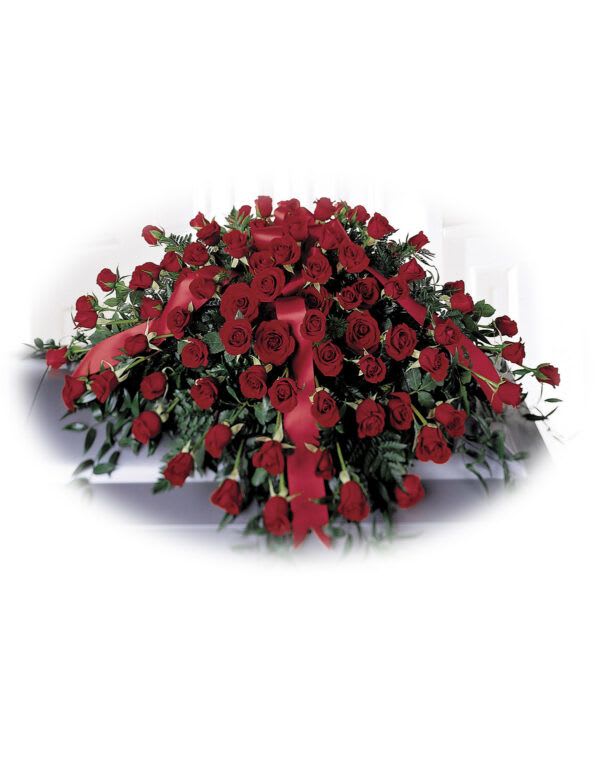 Large arrangement of red roses with ribbon on a white casket