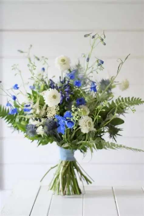Seaside Whisper Bouquet - Our Seaside Petals bouquet is mix of sea colors and flowers accented with greens is wrapped with Love at the Cabin! Colors and flowers will vary due to availability.
